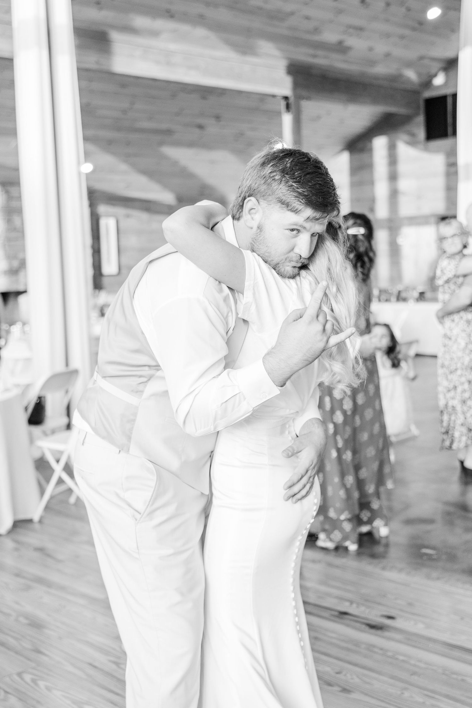 Candid black and white photo of a wedding couple's emotional dance embrace.