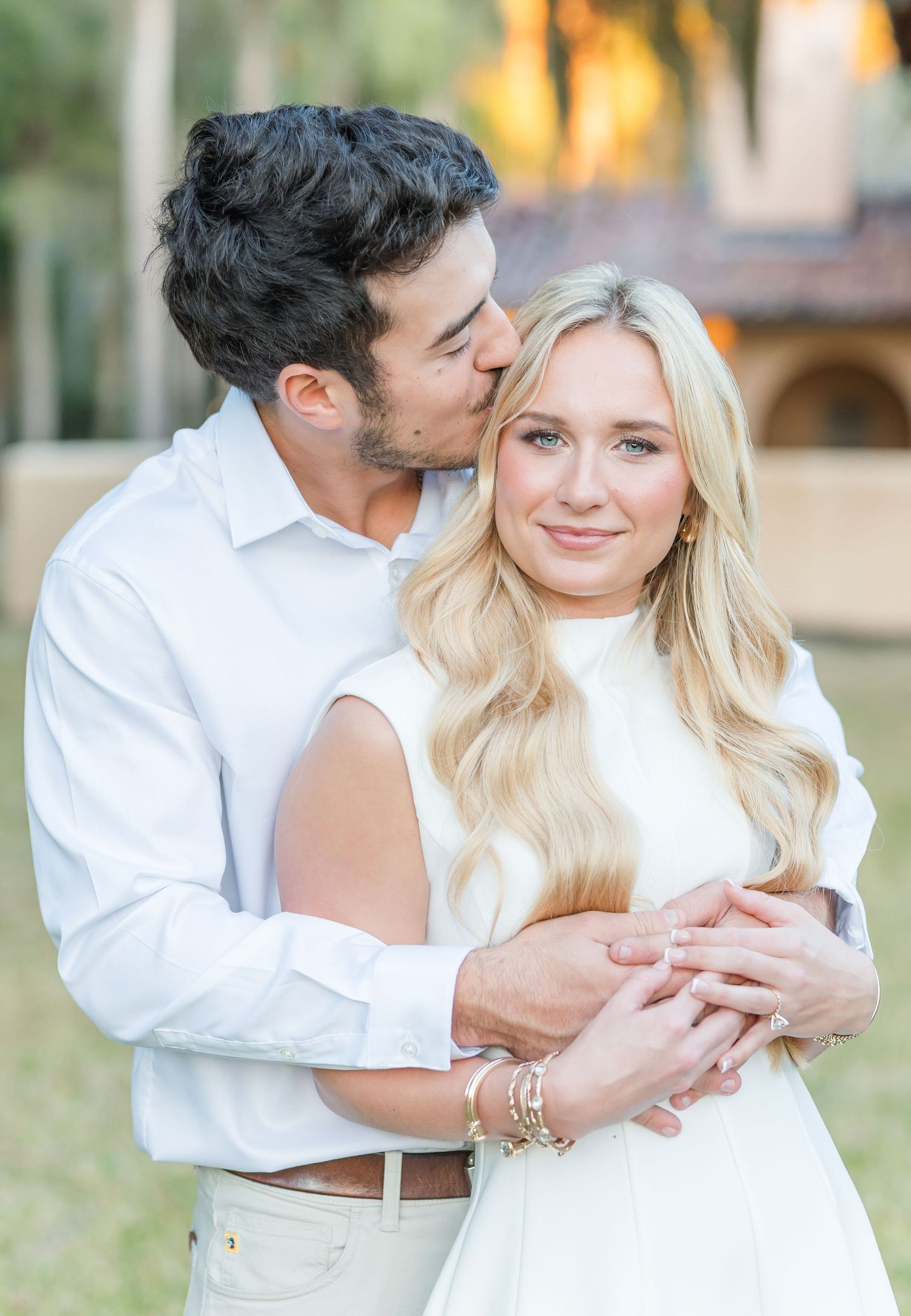 A tender romantic moment captured between a couple in white clothing during golden hour.