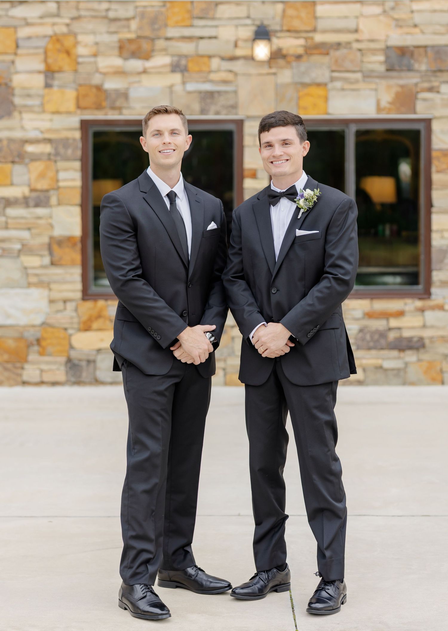 Groomsmen in black suits show off their matching socks and shoes.