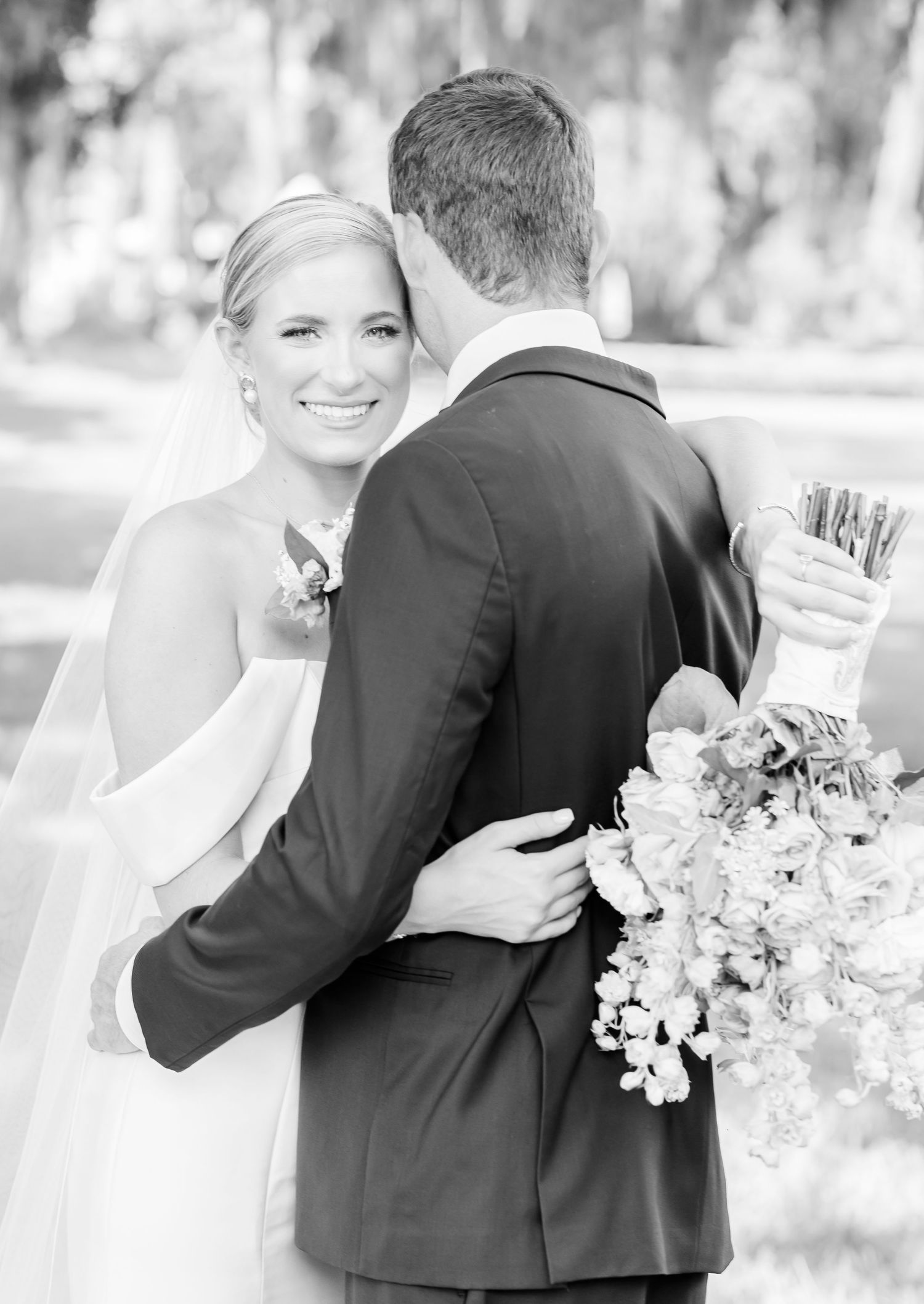 A black and white wedding portrait capturing a joyful moment between the newlyweds.