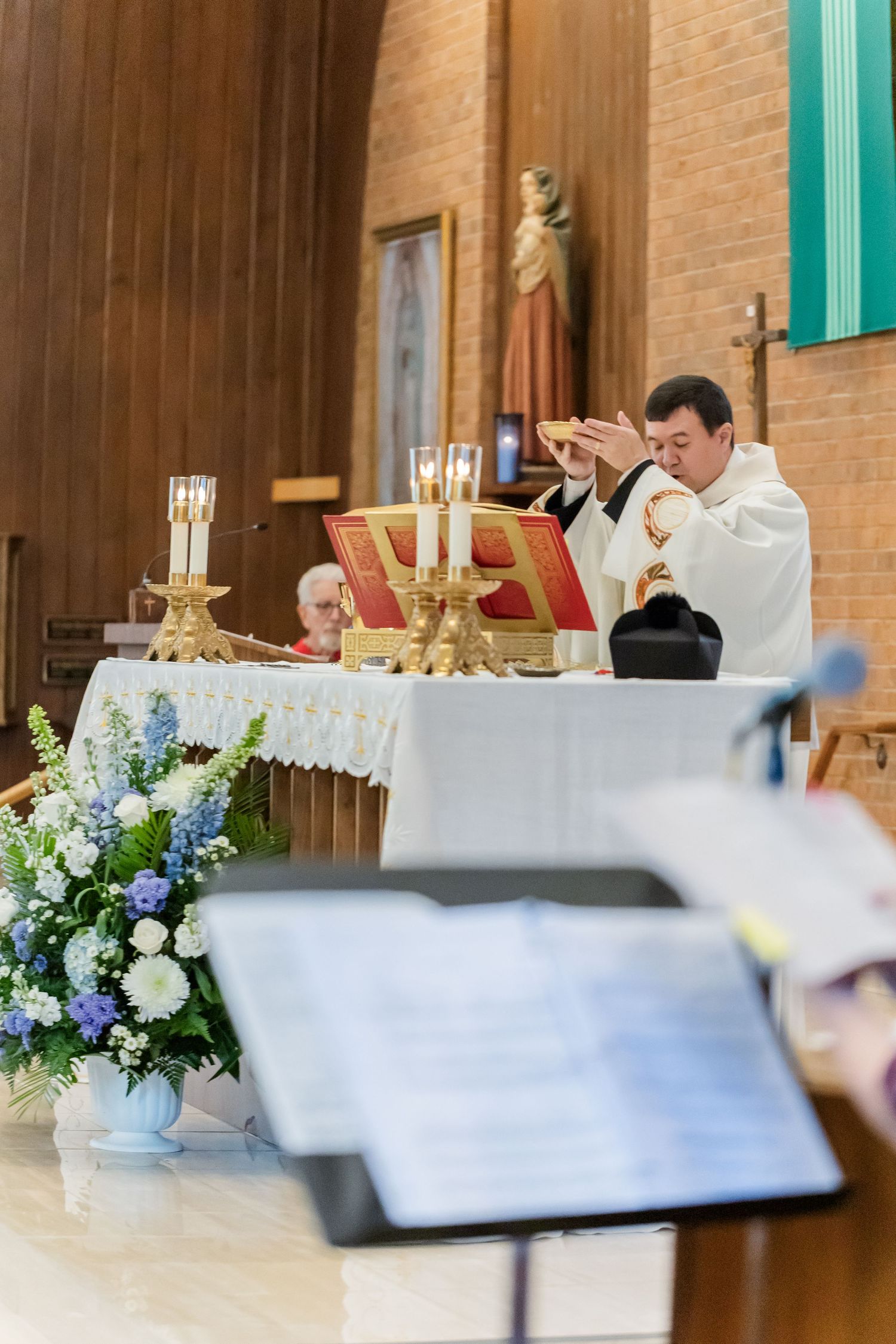 Church altar decorated with blue and white floral arrangements for wedding ceremony.