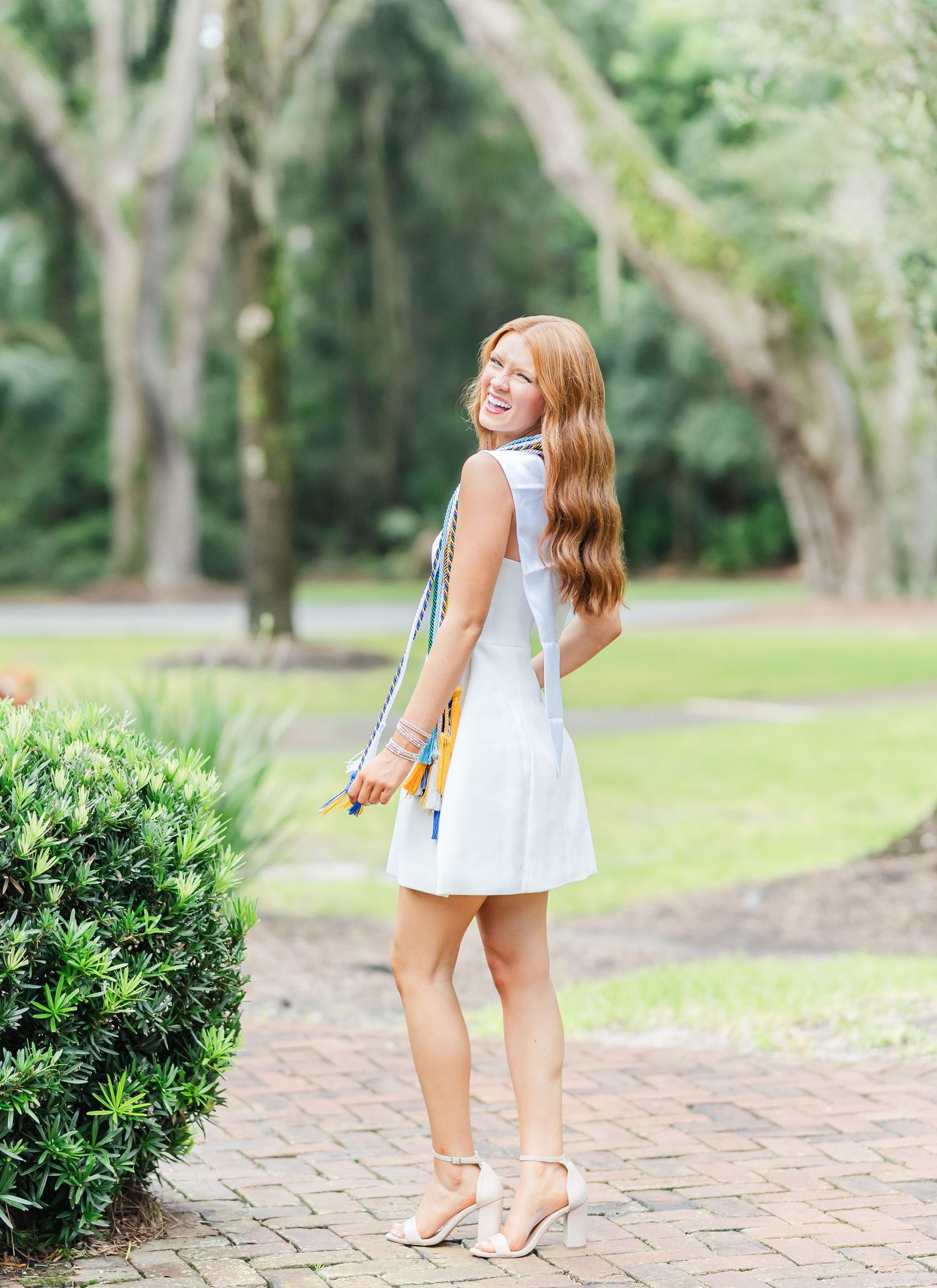 A series of candid shots featuring someone in a light blue sundress walking along a stone pathway in a garden setting.