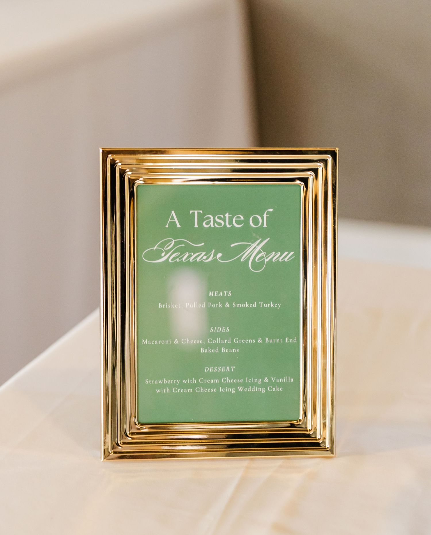 Gold-framed green menu card reading A Taste of Texas Menu with meal options for a wedding reception.