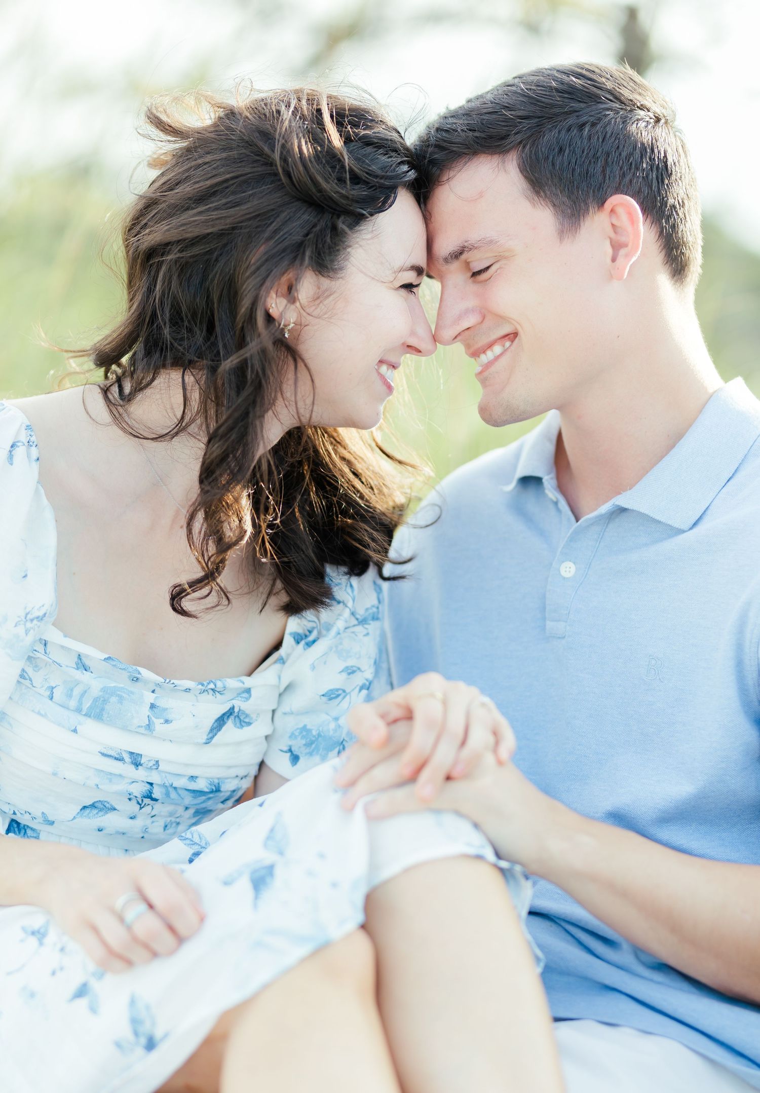 A romantic couple in light blue and white outfits embrace lovingly on a sunny day in a series of four intimate shots.