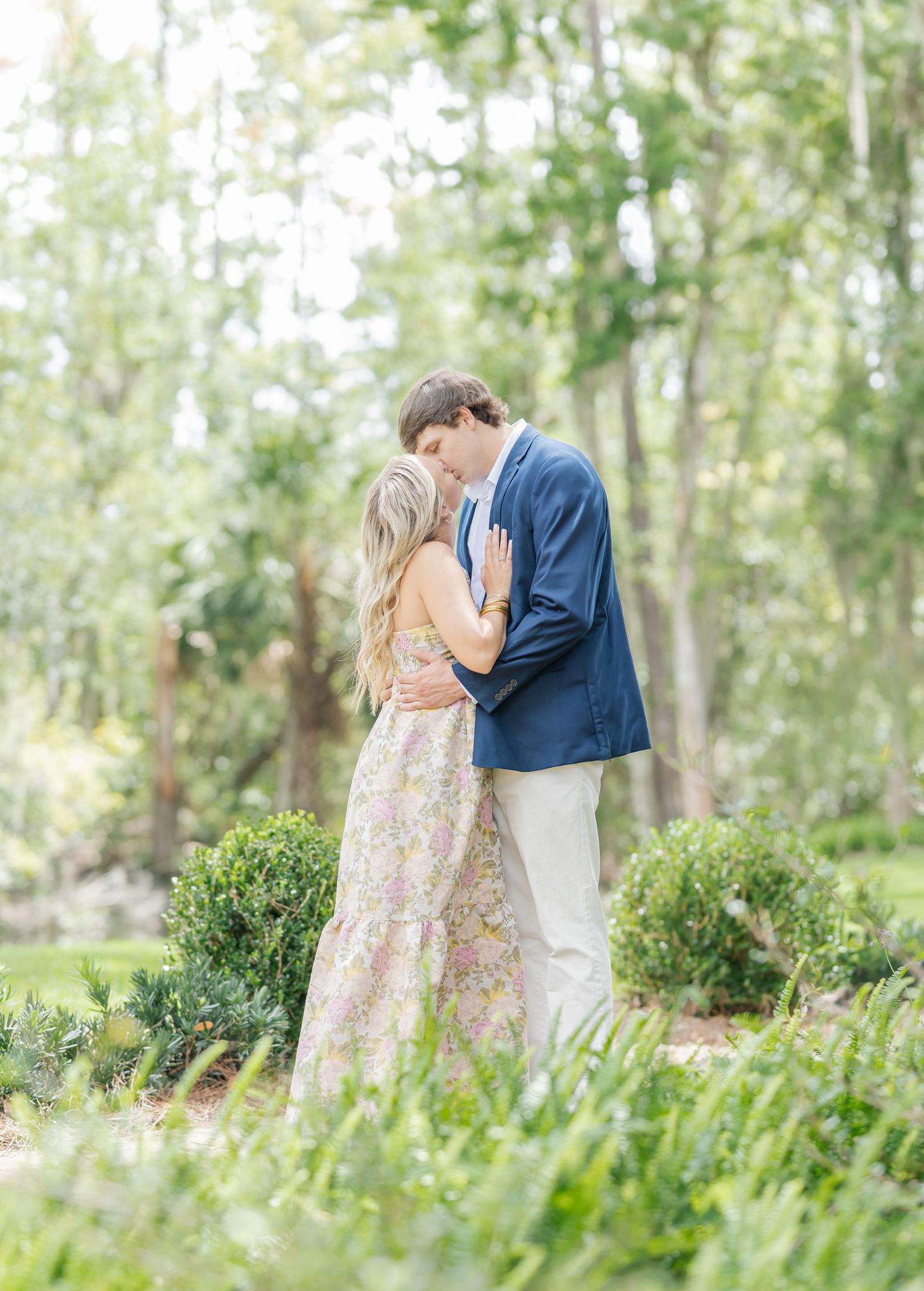 Couple in spring garden sharing intimate moments among blooming greenery.