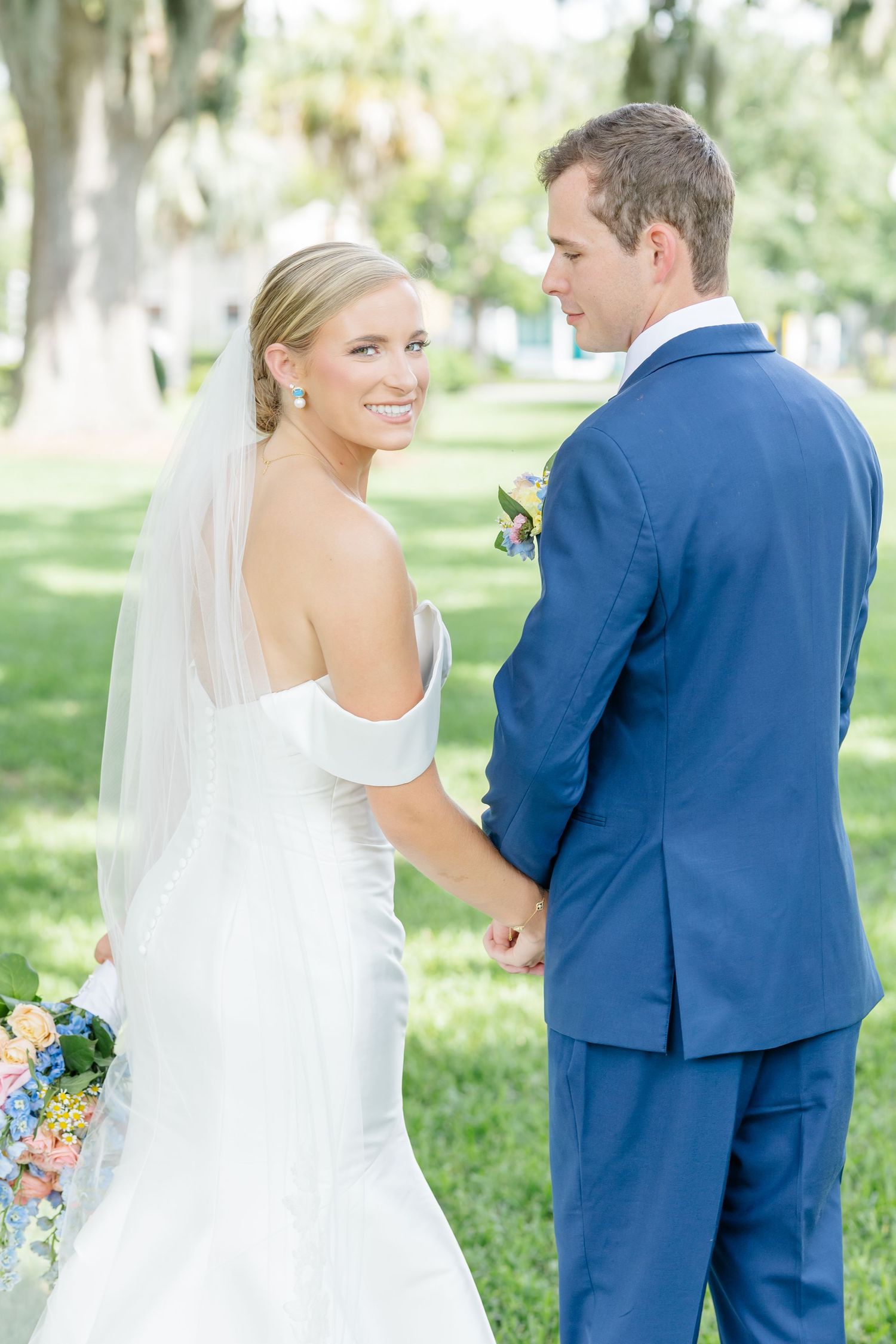 A series of romantic first look photos showing a bride and groom meeting in a sunlit garden setting.