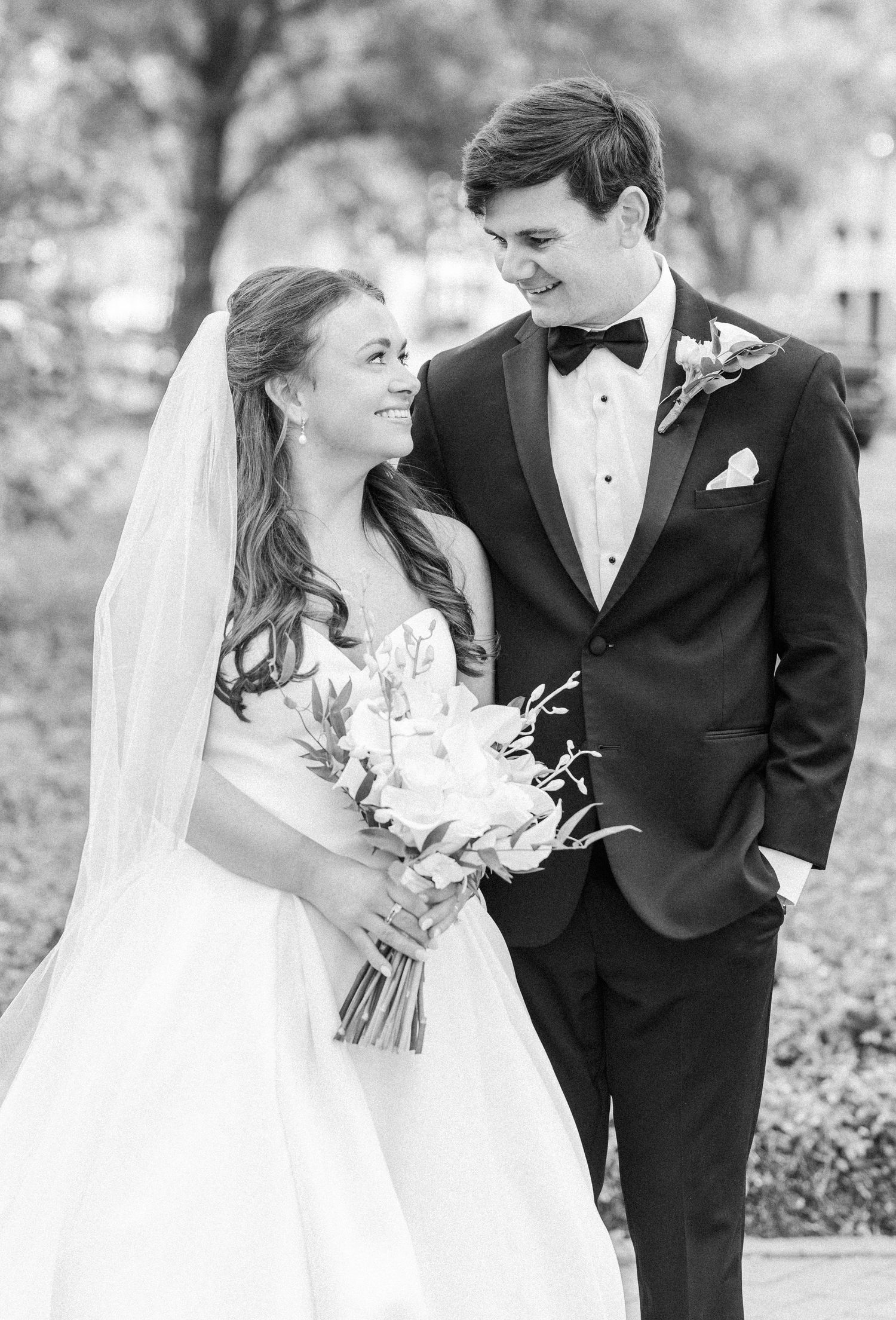 Romantic wedding portraits showing couple in black tuxedo and white gown with bouquet.