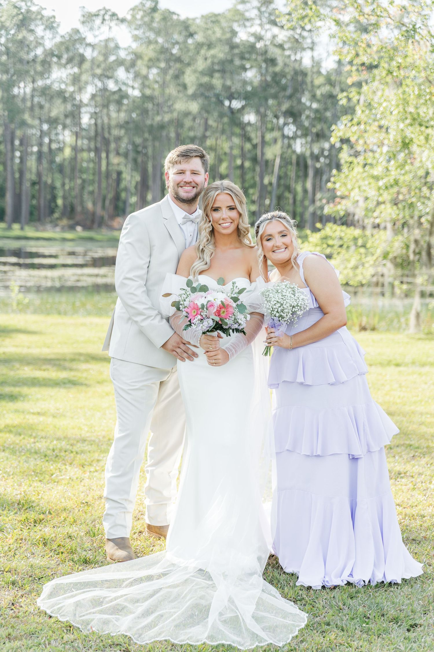 Ethereal wedding photo with bridal party in white and lavender gowns holding pink and white bouquets.