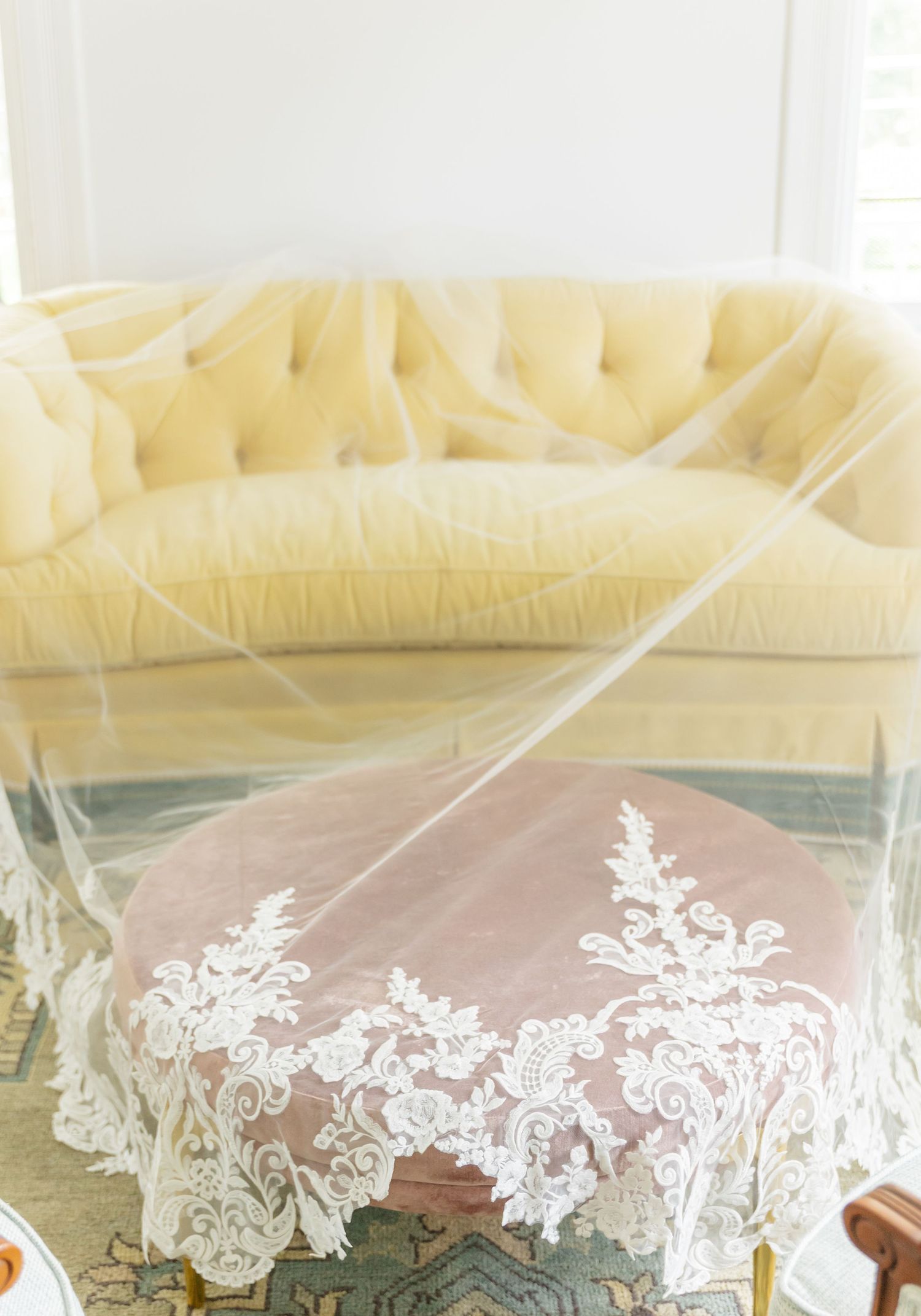Delicate white lace details adorn a draped canopy with soft yellow fabric in an elegant wedding setup.