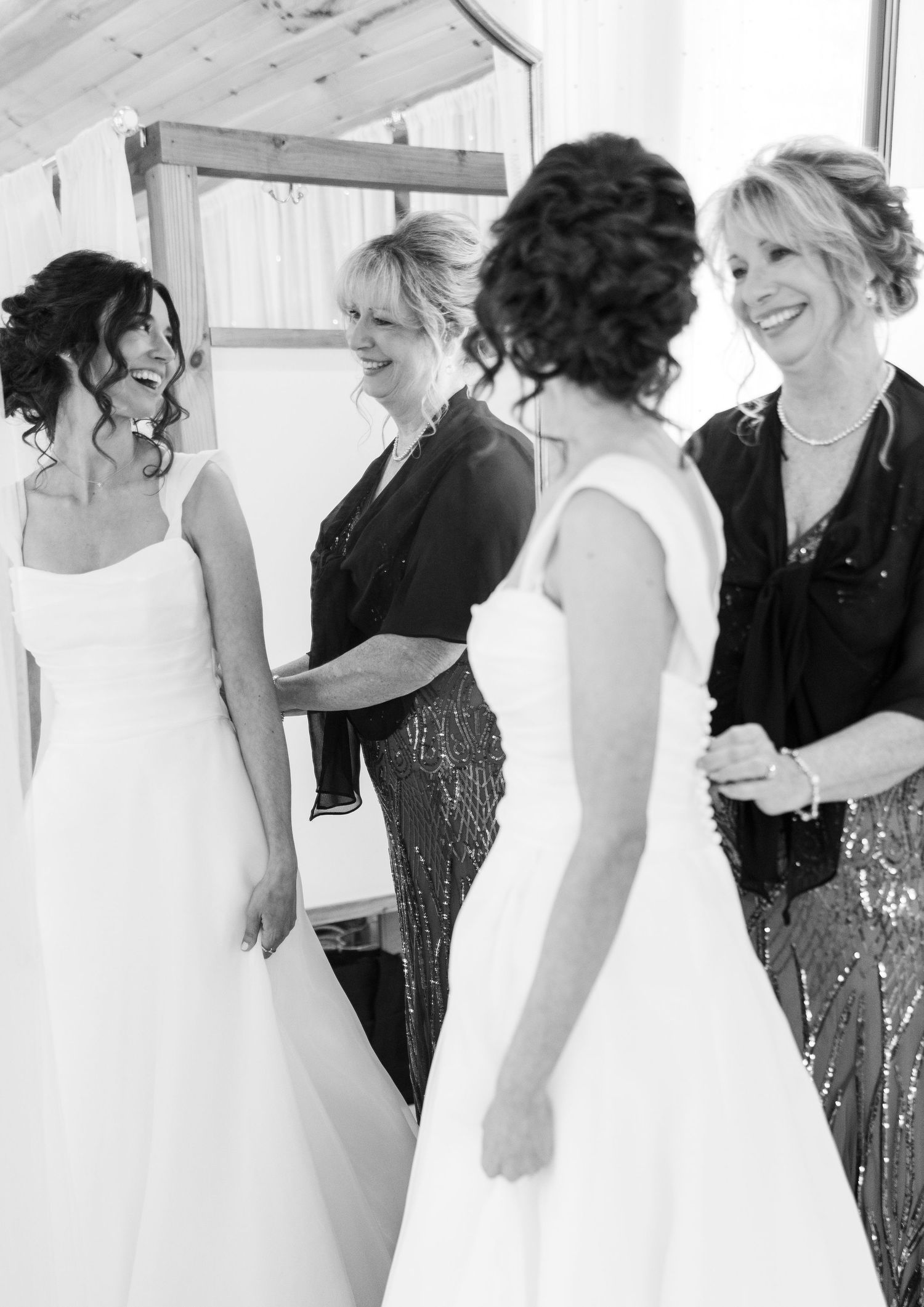 A black and white panoramic photograph showing a group of people in formal wedding attire standing in a line.