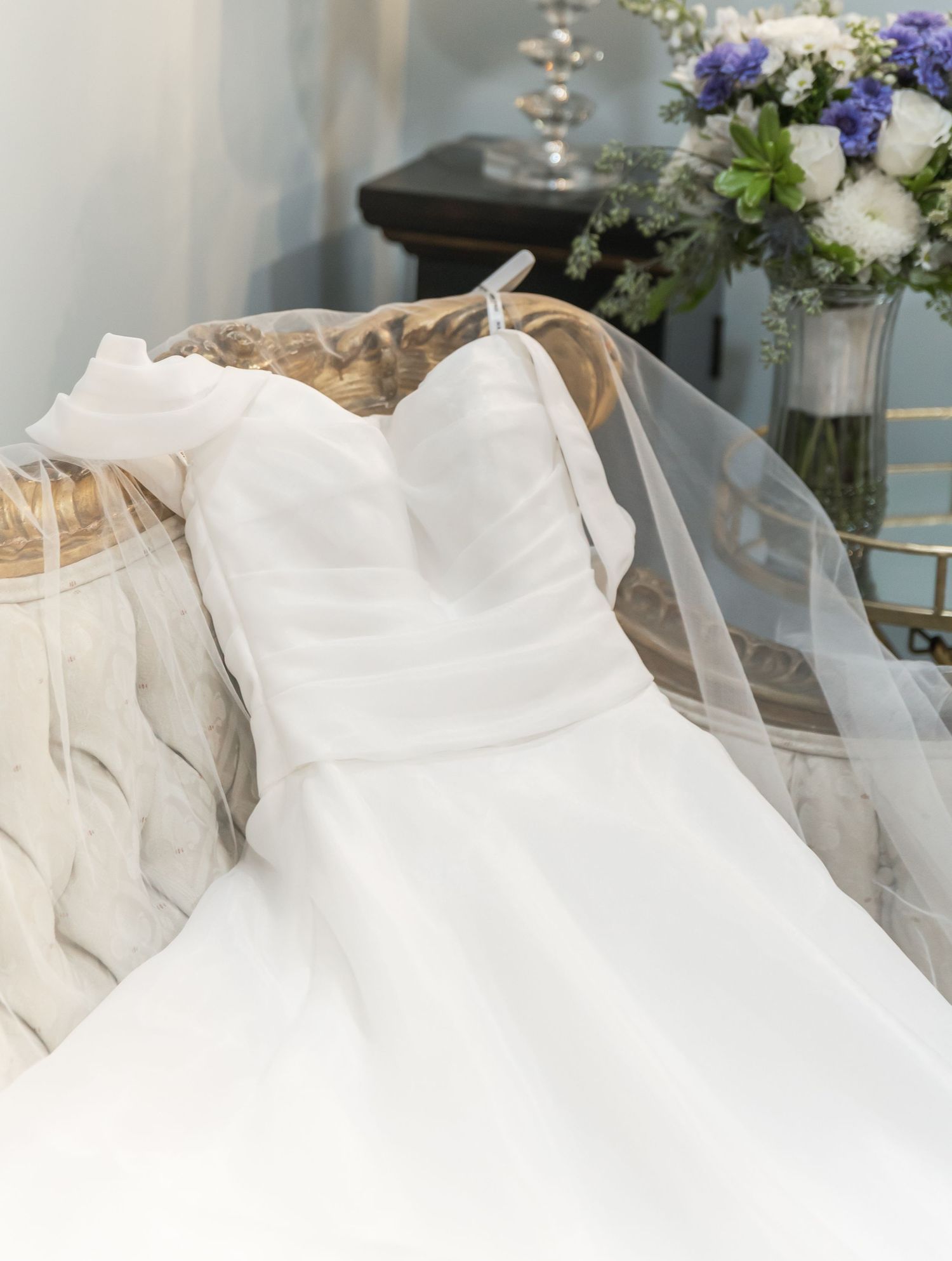 Elegant white wedding dress train with delicate tulle fabric draped and flowing across the floor.