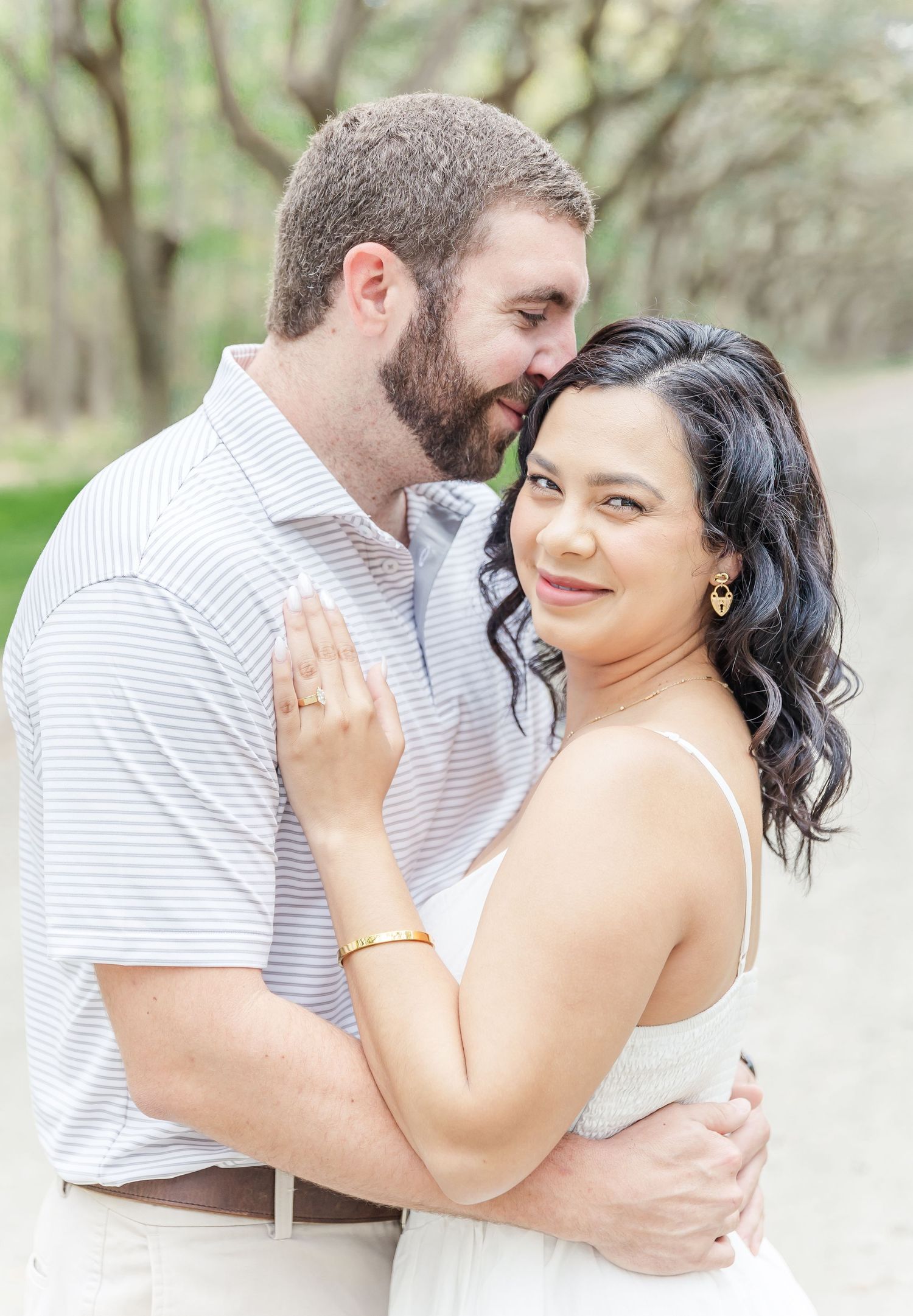 Couple sharing an intimate moment while posing for engagement photos in a natural setting.