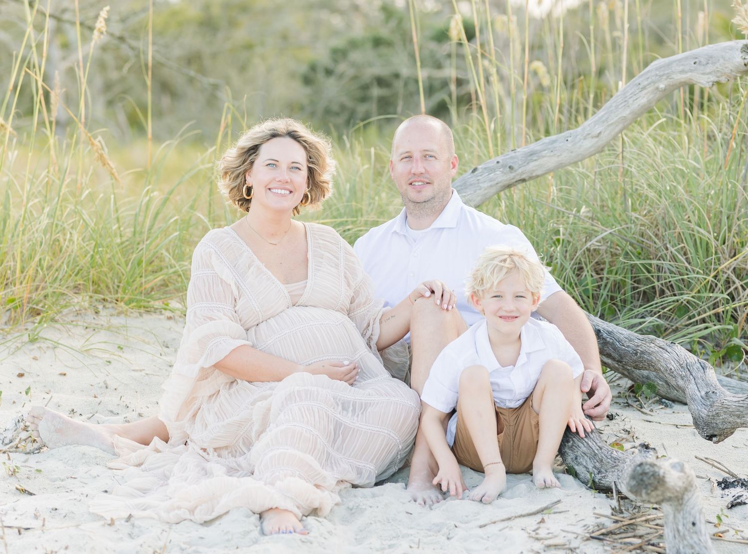 Casual family photos captured in natural light on a beach with sea grass.