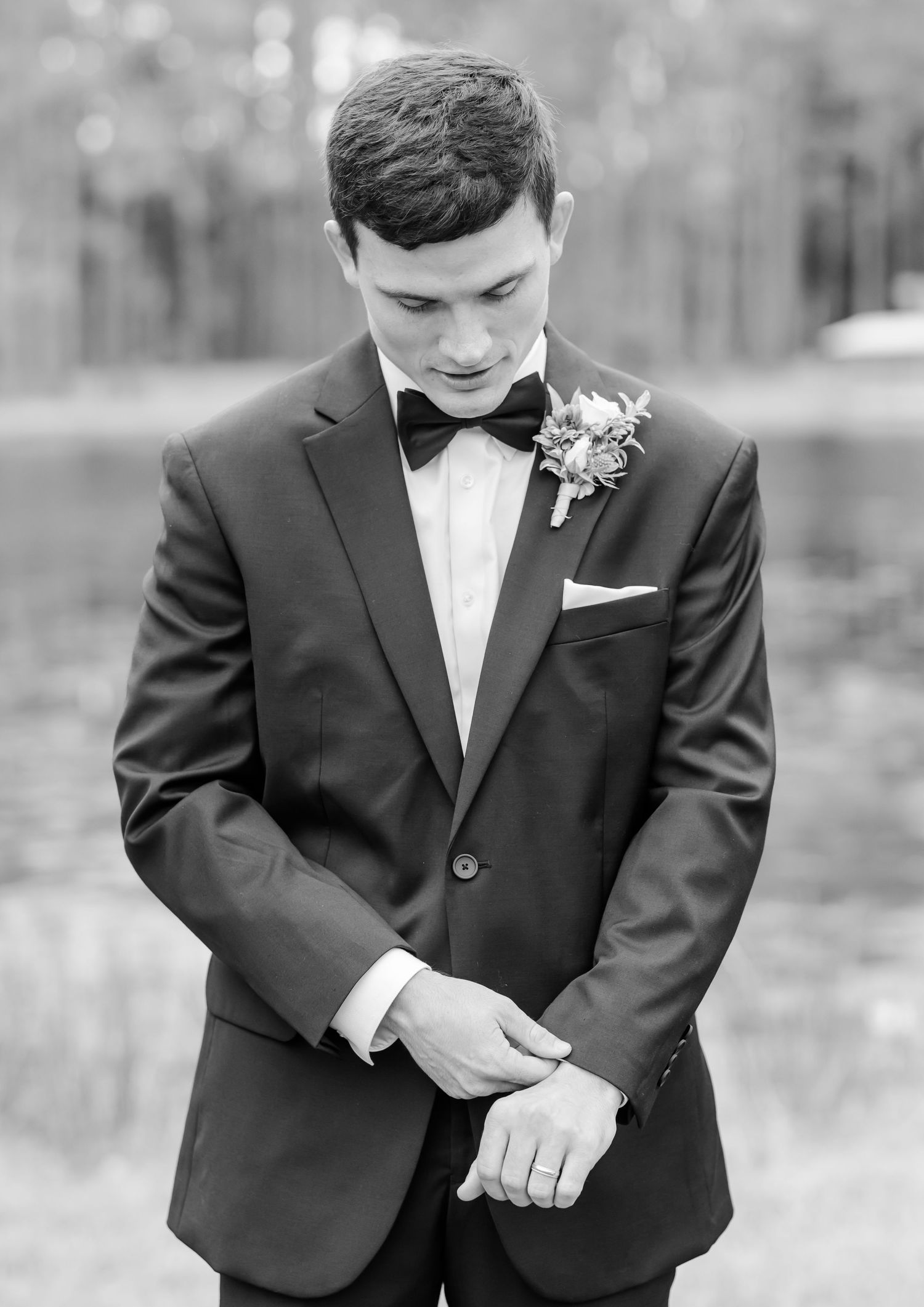 Black and white photo series showing details of a groom adjusting his formal tuxedo and bow tie.