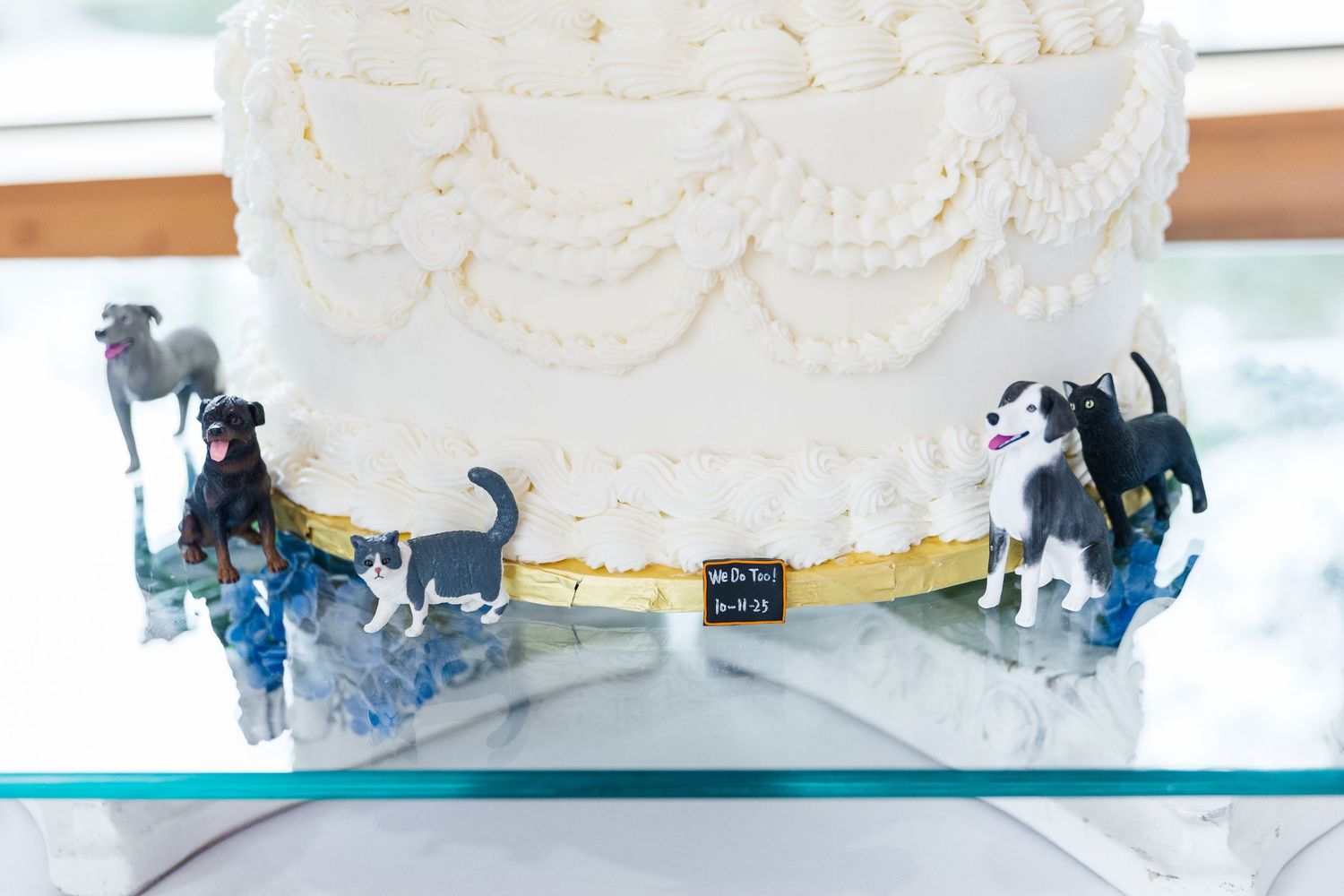 A close-up view of white frosting being piped onto a cake in a decorative swirled pattern.