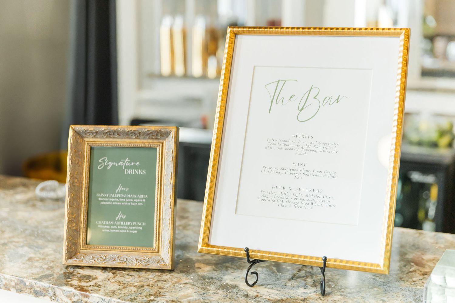 Gold-framed wedding signage and menu cards displayed on an elegant surface.