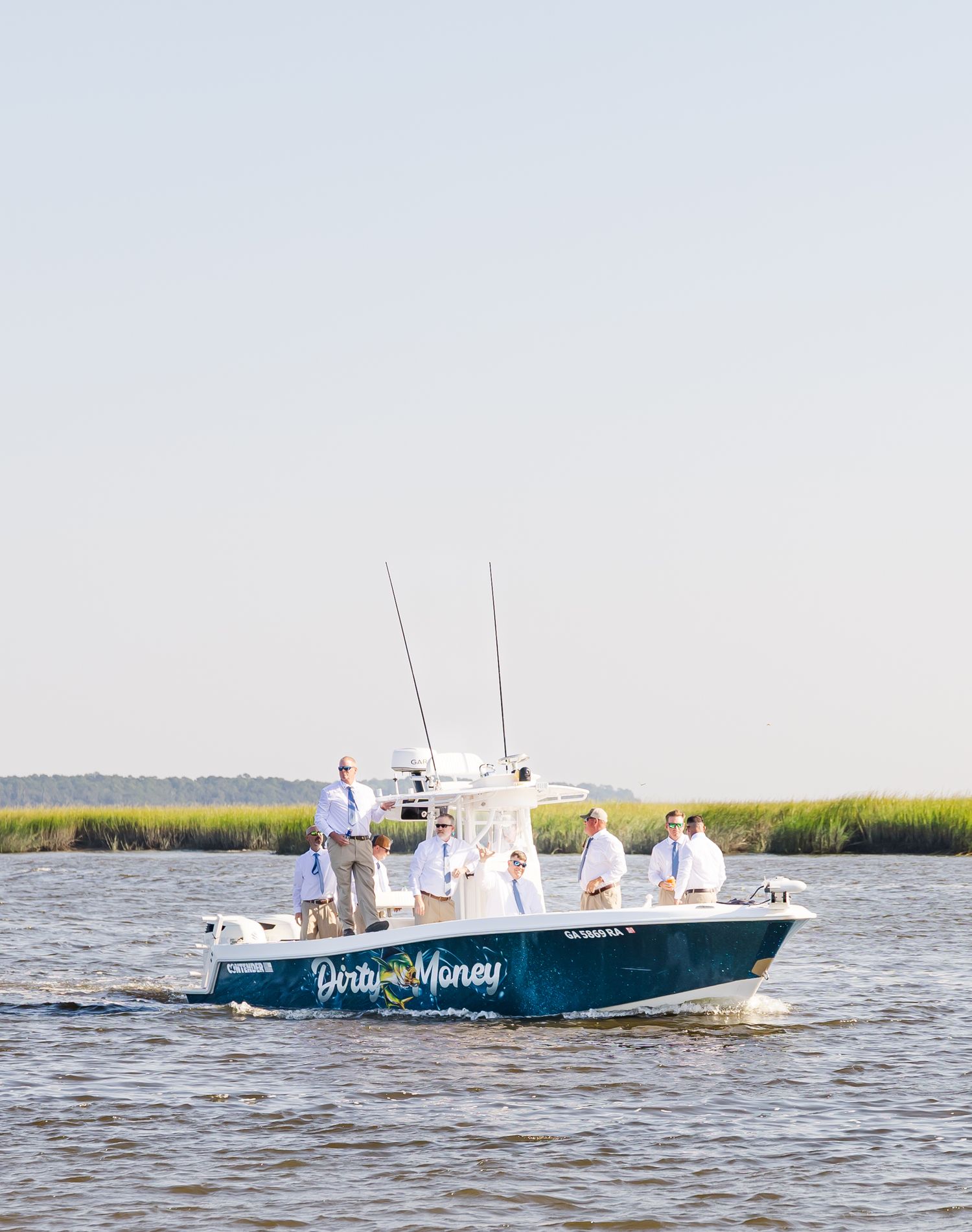 A sequence of four photos showing a blue and white fishing boat cruising through coastal waters near marsh grass.