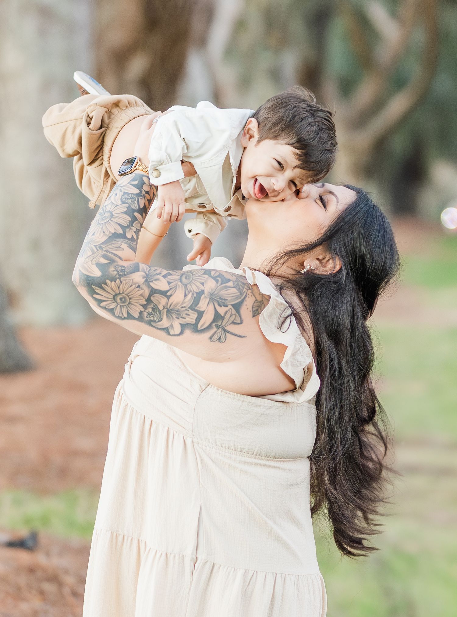 Sweet candid moments captured of a family embracing and laughing together in a natural outdoor setting.