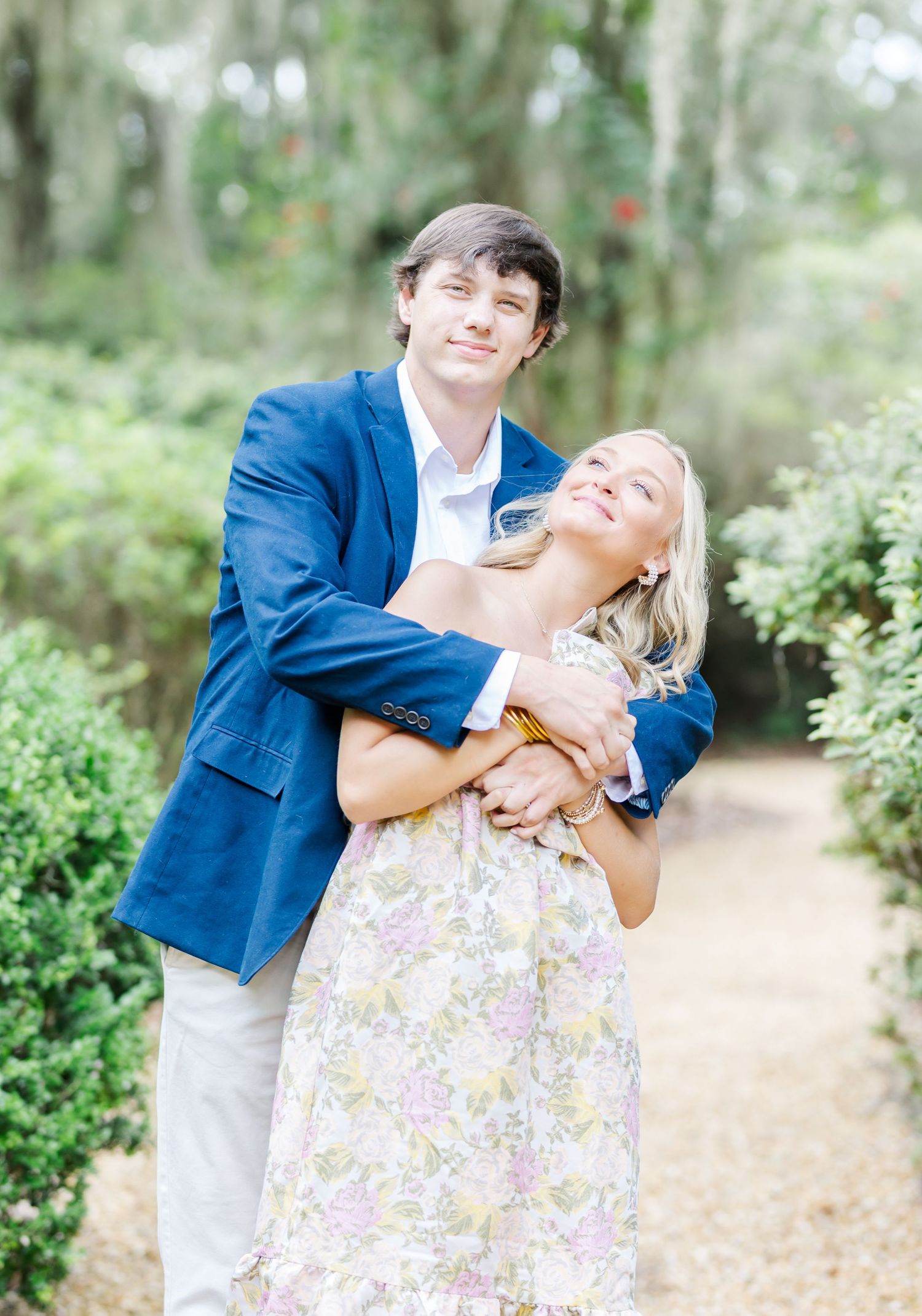 A joyful moment captured between a couple in a garden setting with Spanish moss hanging overhead.