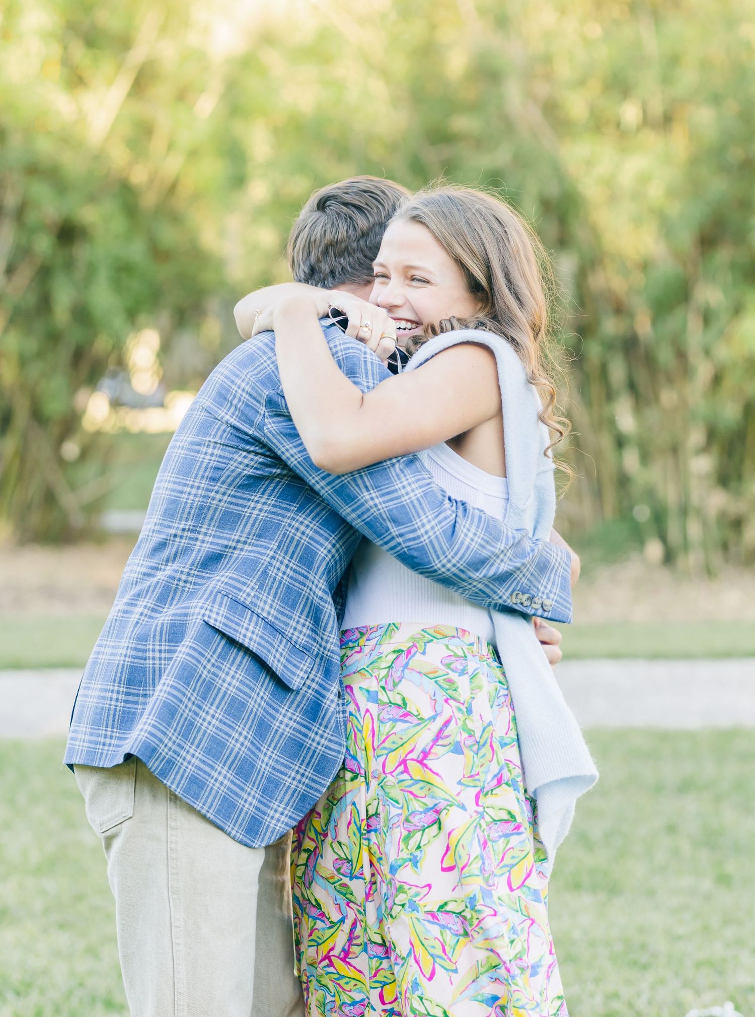 An emotional embrace shared between two people in a garden setting.