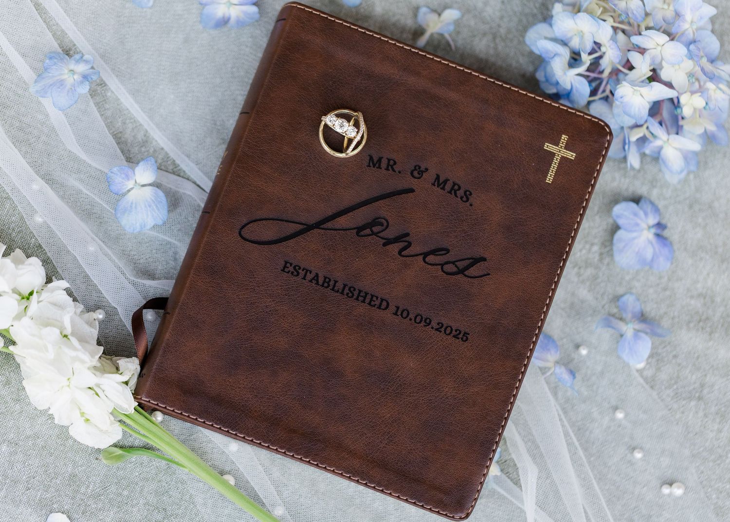 Personalized brown leather wedding Bible cover engraved with Mr. and Mrs. Jones established date and gold cross.