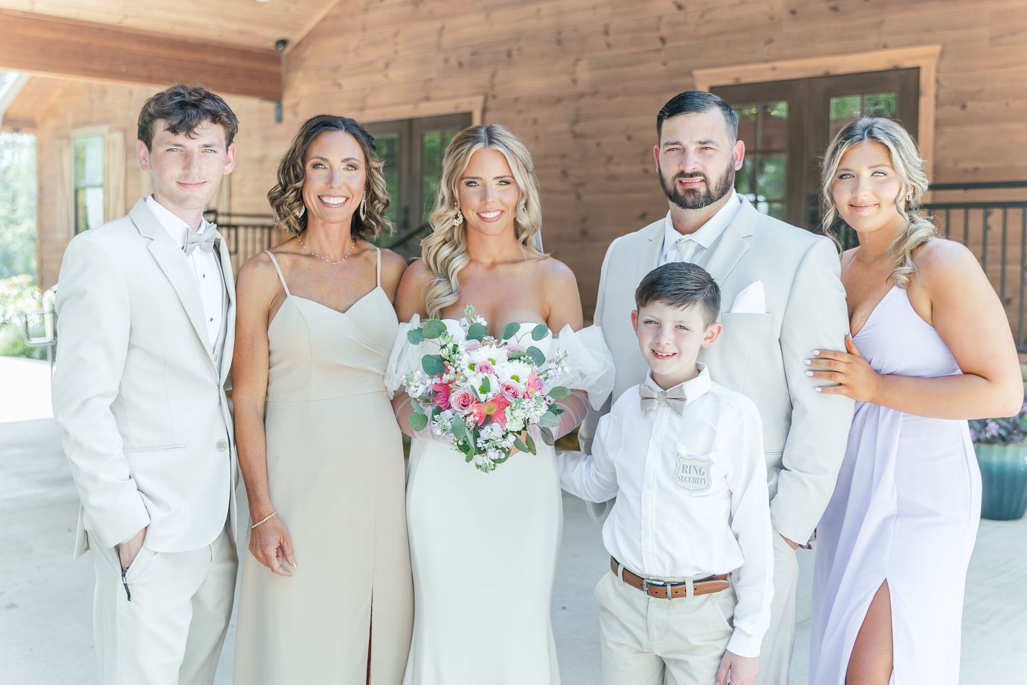 Wedding group portrait with coordinated white and cream formal attire.