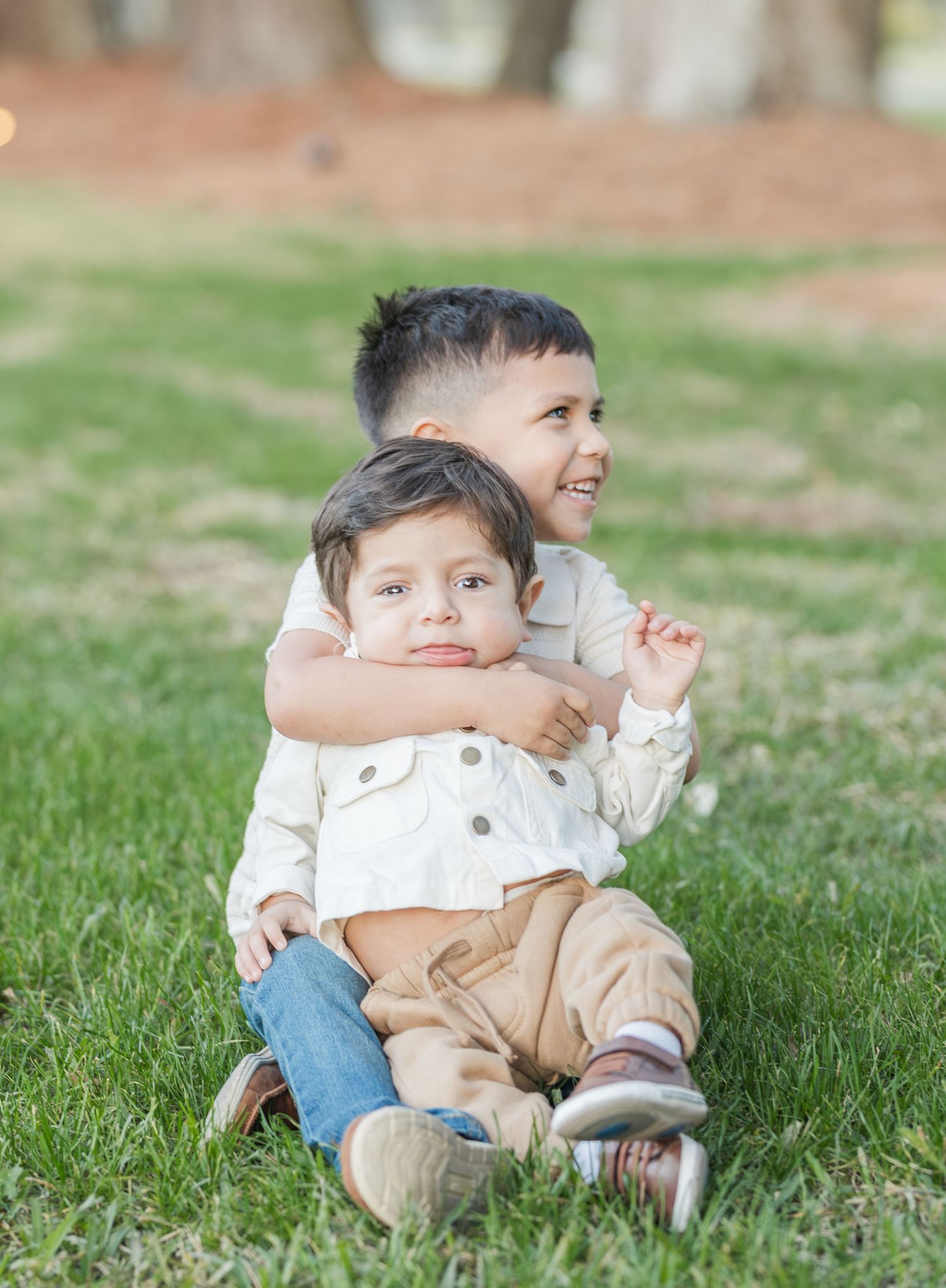 Candid shots of joyful playtime on grassy lawn during outdoor photo session.