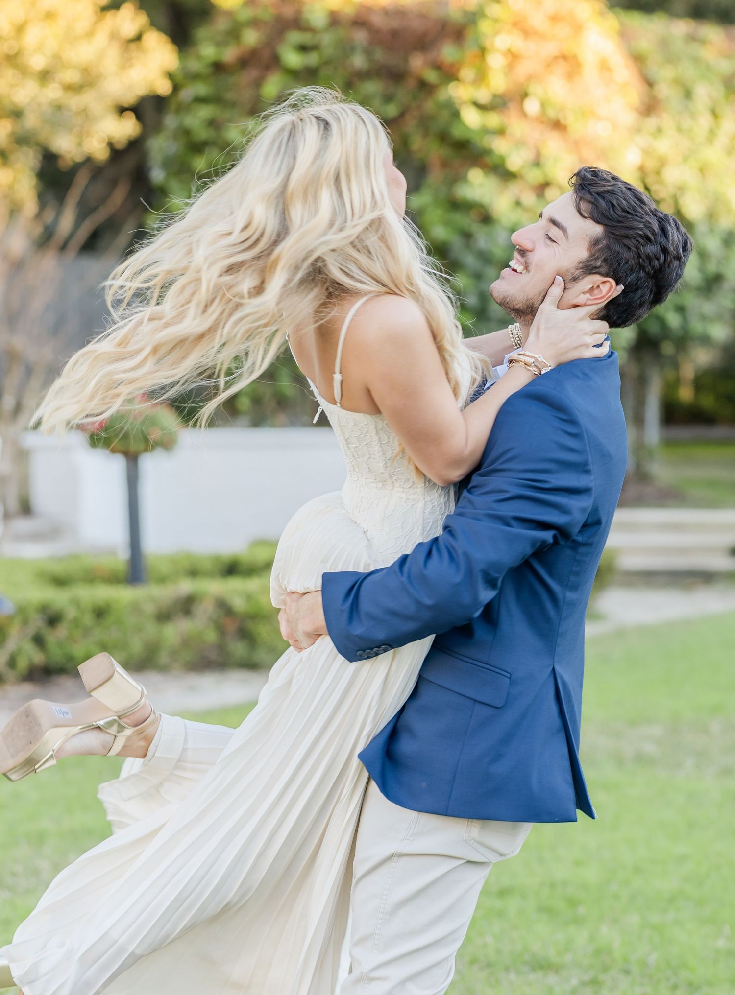 Joyful spinning dance sequence in a garden with a blue suit and flowing white dress.