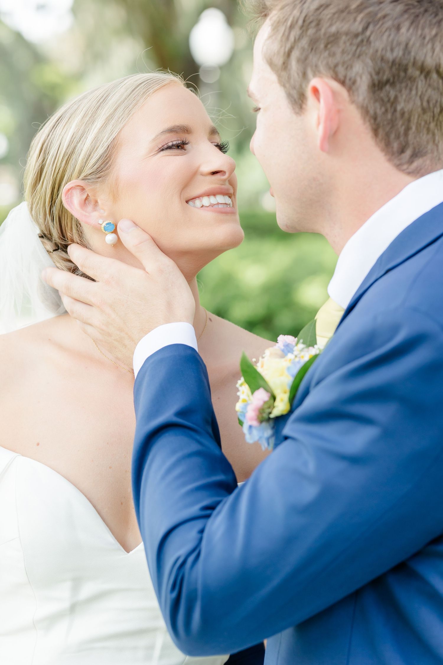 A tender moment between newlyweds as they share an intimate embrace outdoors, with the bride wearing turquoise earrings.