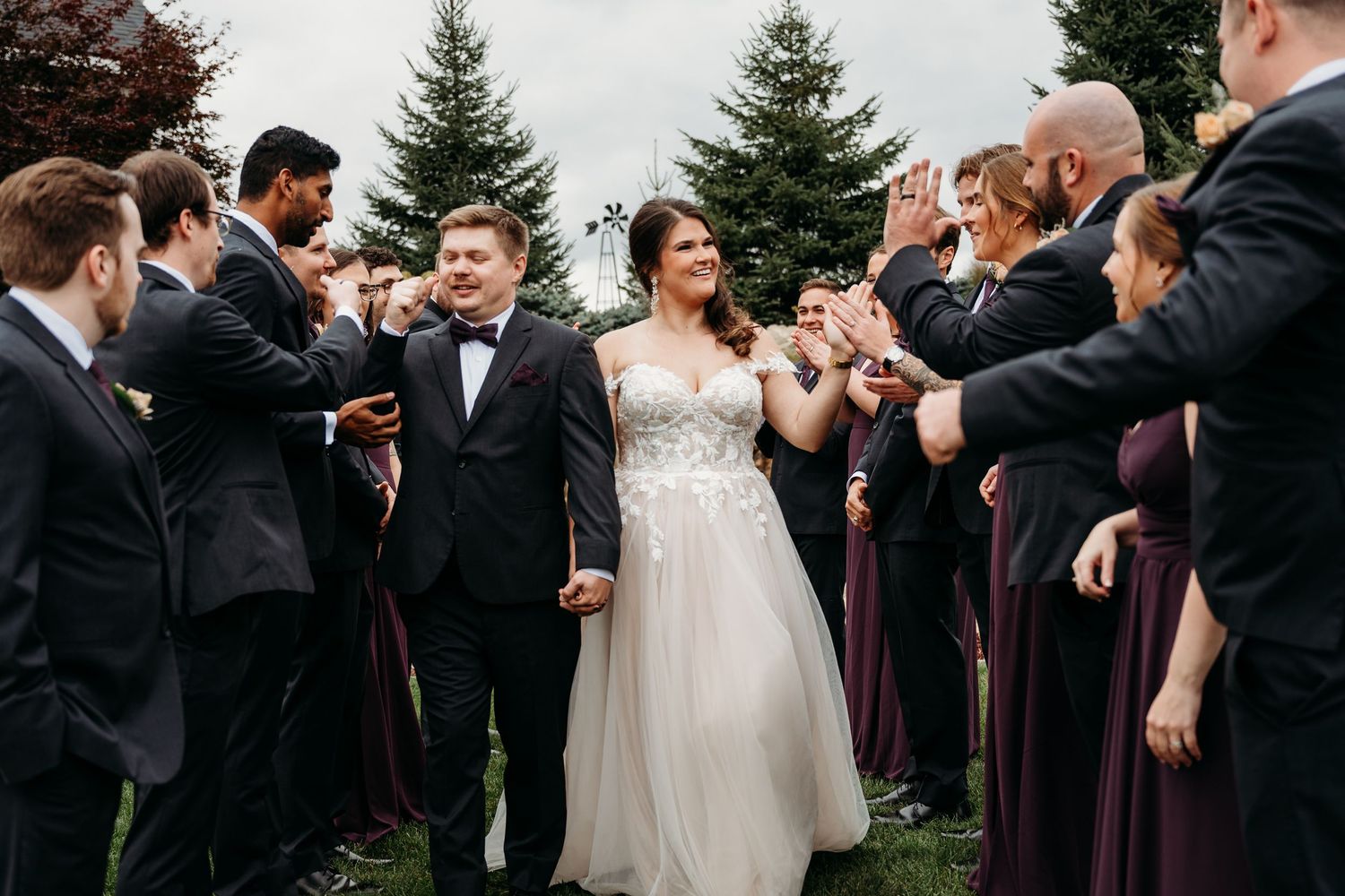 Wedding party members celebrate outdoors with joyful reactions during a special moment at the ceremony.