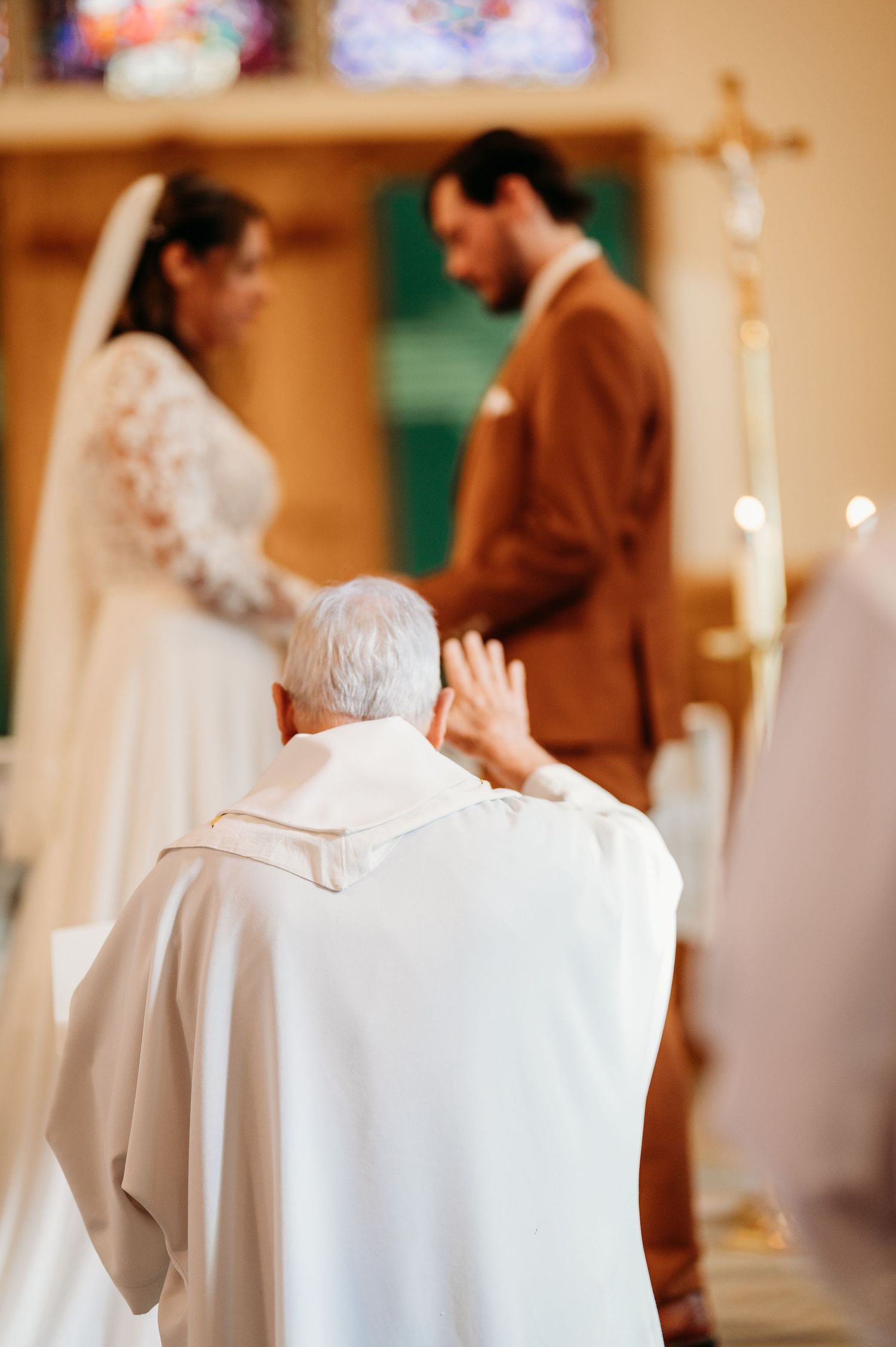 Religious ceremony with clergy in white robes conducting service in church setting.