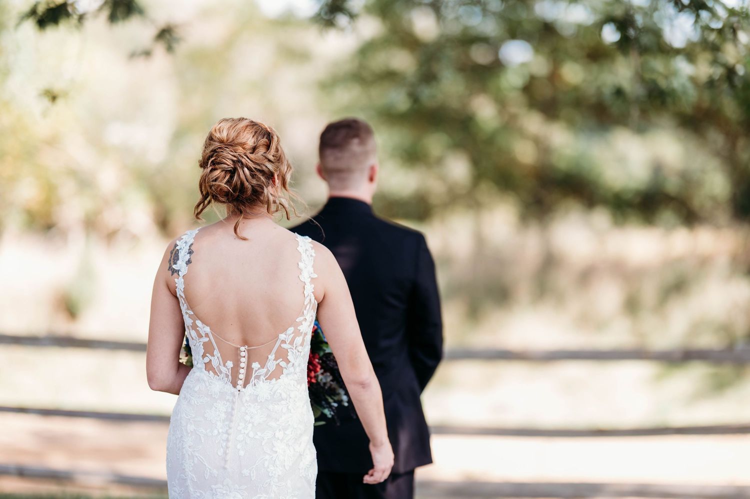 A couple shares a tender moment during their outdoor wedding ceremony in a natural setting.