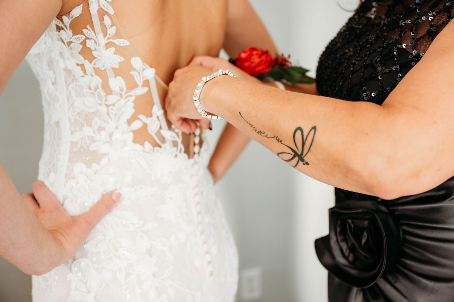 A bride and groom pose together in formal wedding attire with black and white color scheme.