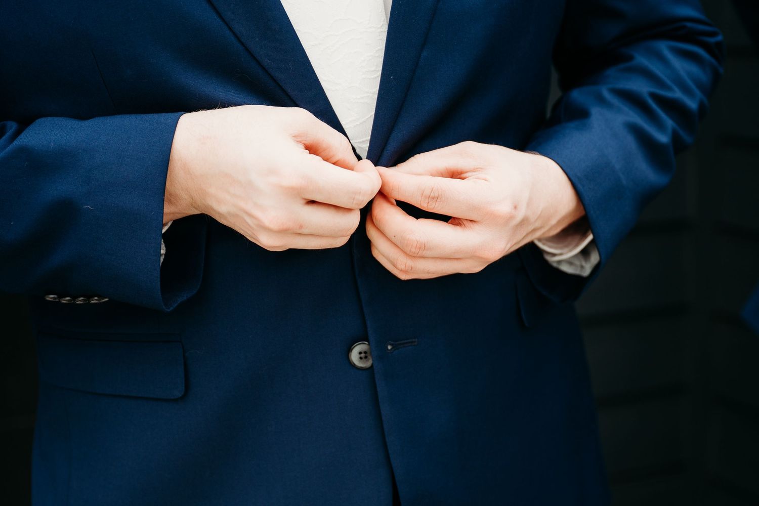 Close-up detail shot of hands holding a ring during a formal ceremony engagement.