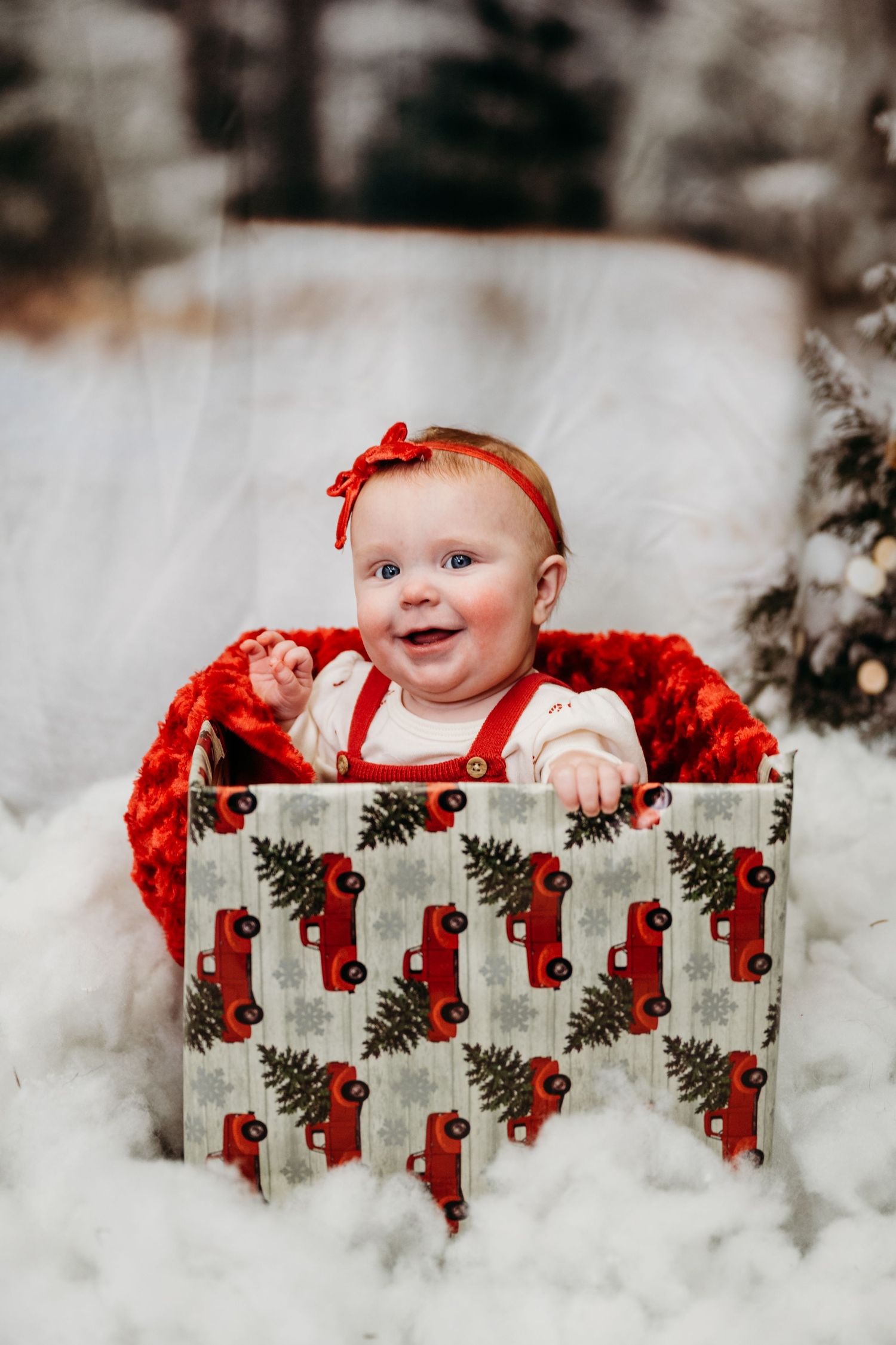 Holiday photo featuring a decorative gift box with vintage red truck pattern and festive decor.