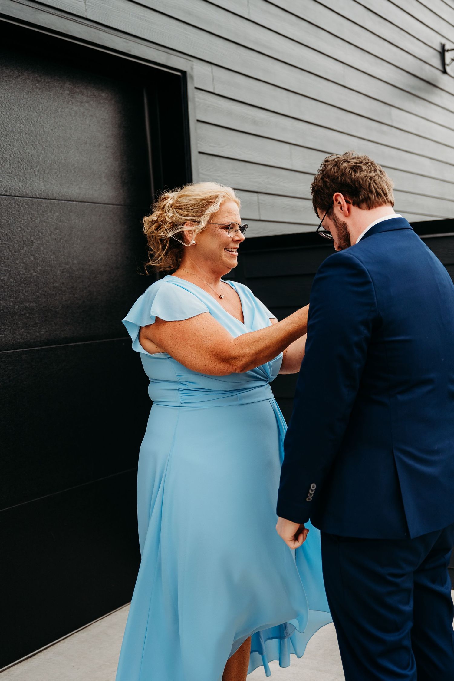 Four sequential photos show an emotional first look moment between a couple as the bride approaches in a light blue dress.