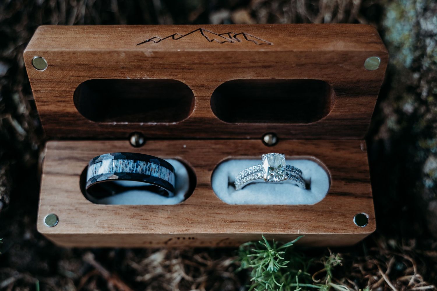 Handcrafted wooden sunglasses with dark lenses displayed on natural moss against a rustic background.
