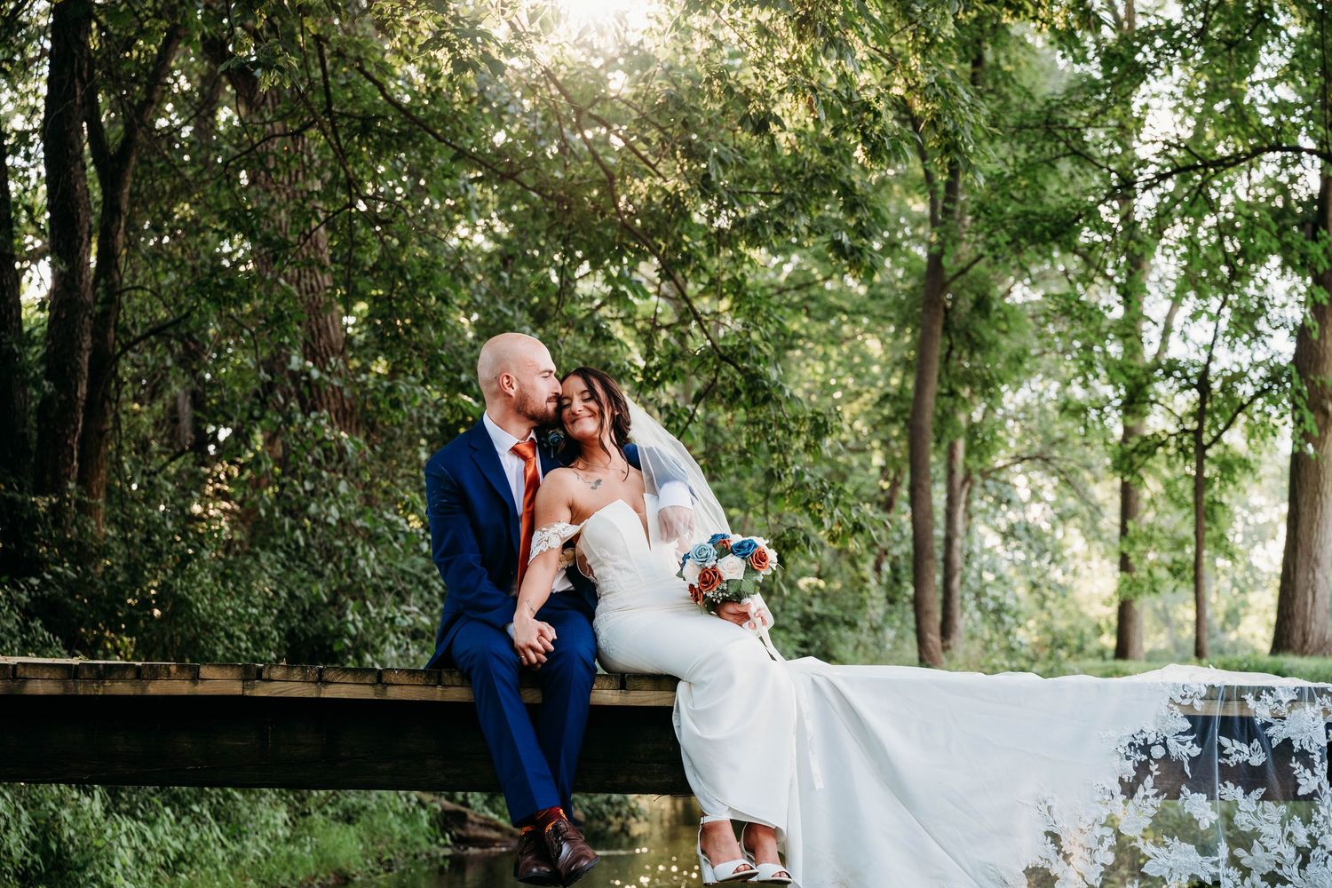 A romantic couple shares intimate moments in a lush garden setting during their outdoor wedding celebration.