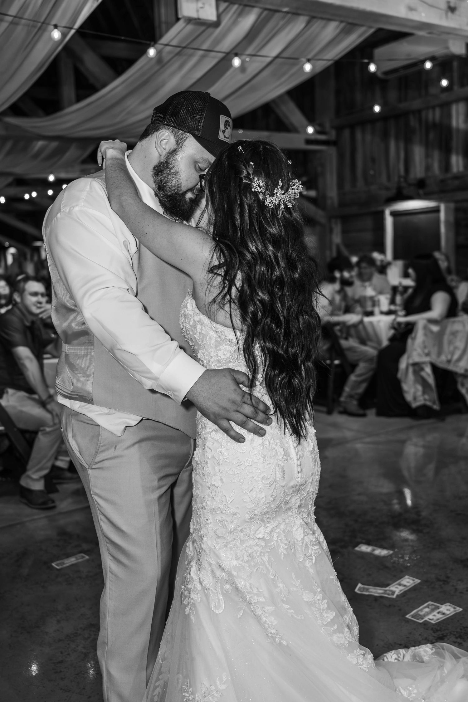Newlyweds share their first dance under twinkling lights at an evening reception.