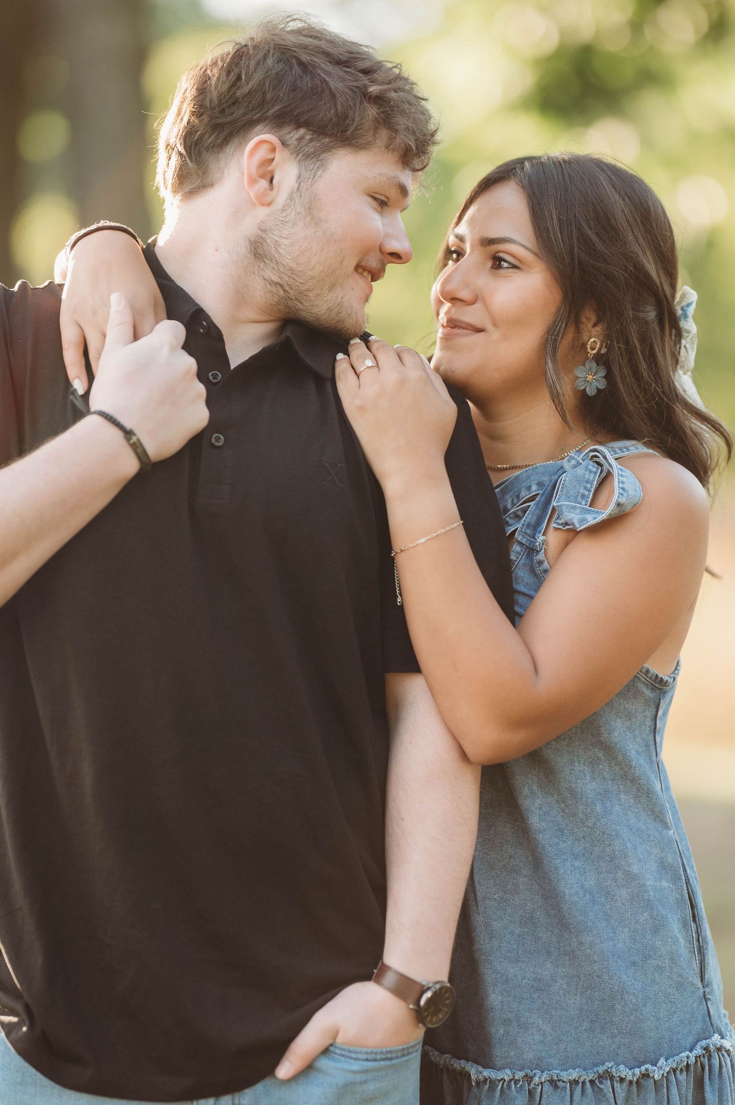 Tender moments captured between a couple in casual attire against a soft, natural backdrop.
