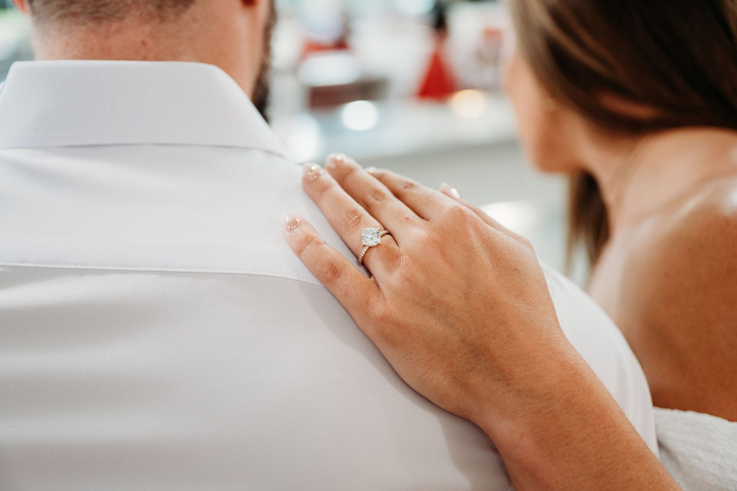 A couple shares a playful moment while drinking coffee at a diner counter.