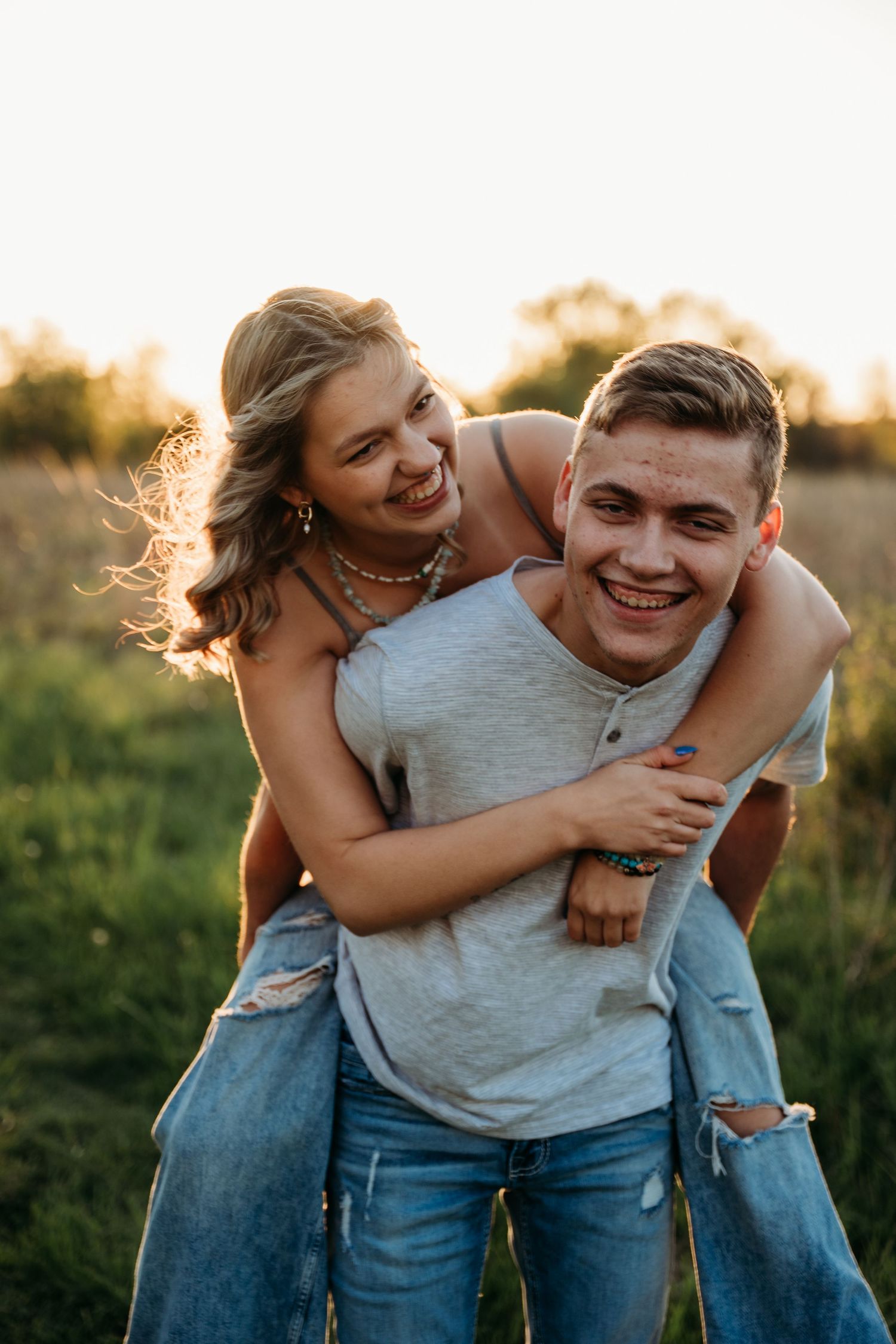 A playful piggyback ride moment captured in warm evening light with natural expressions of joy.