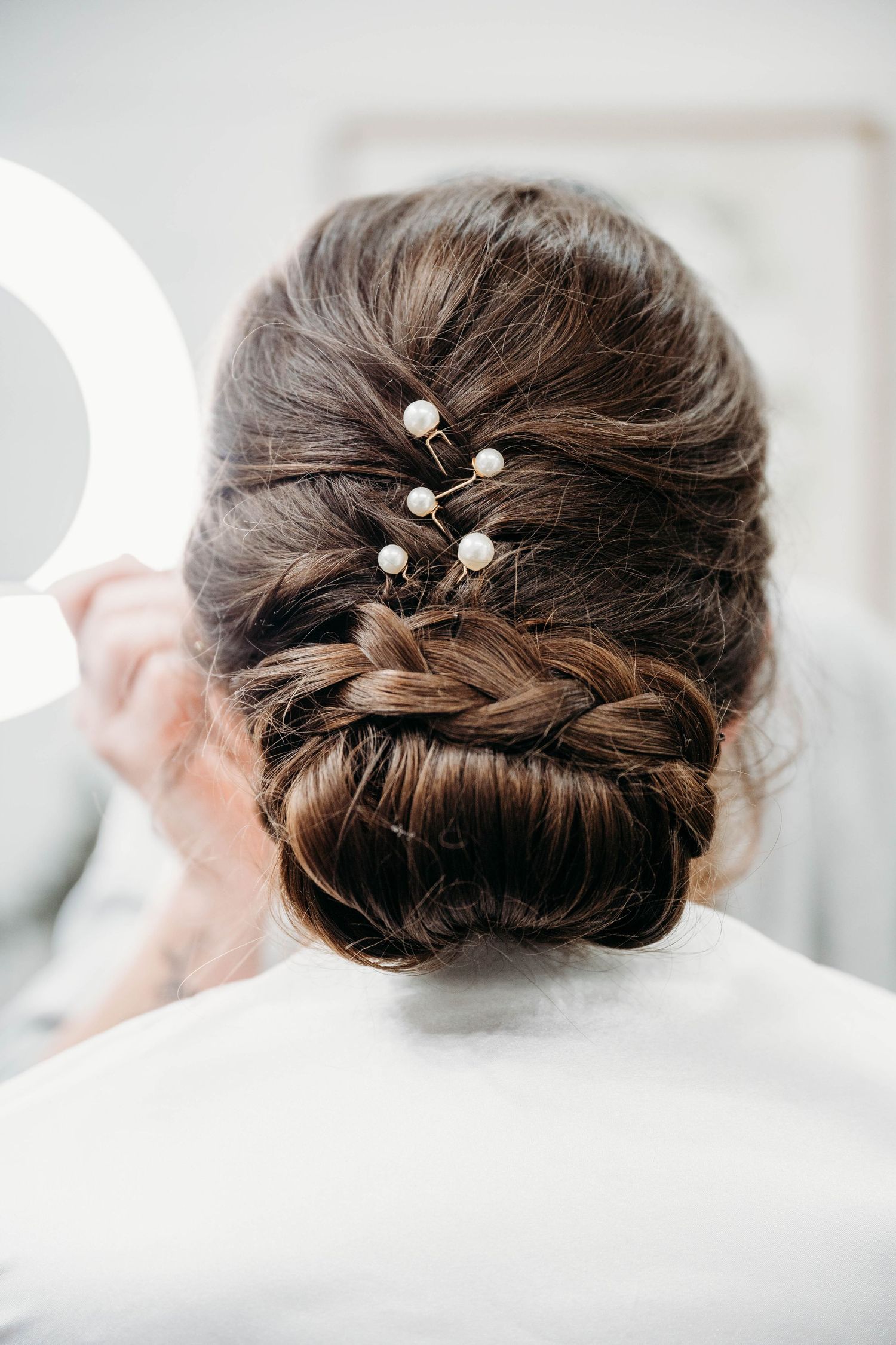 Elegant bridal updo hairstyle shown from multiple angles featuring twisted sections and pearl hair pins.