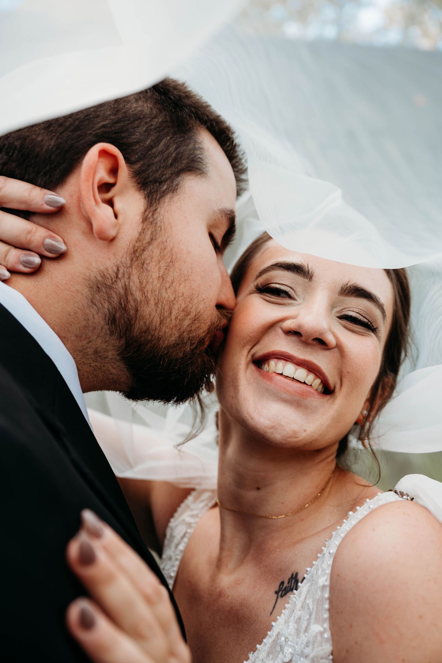 A romantic wedding couple shares tender kisses under a flowing white veil in a series of candid close-up shots.