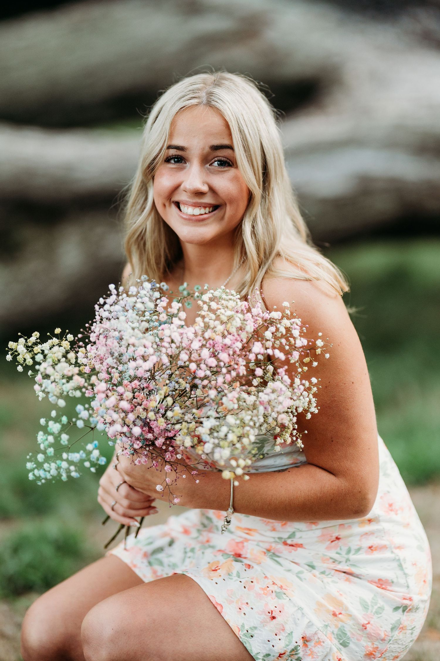 A bright summery portrait featuring delicate baby's breath flowers and a floral print dress outdoors.