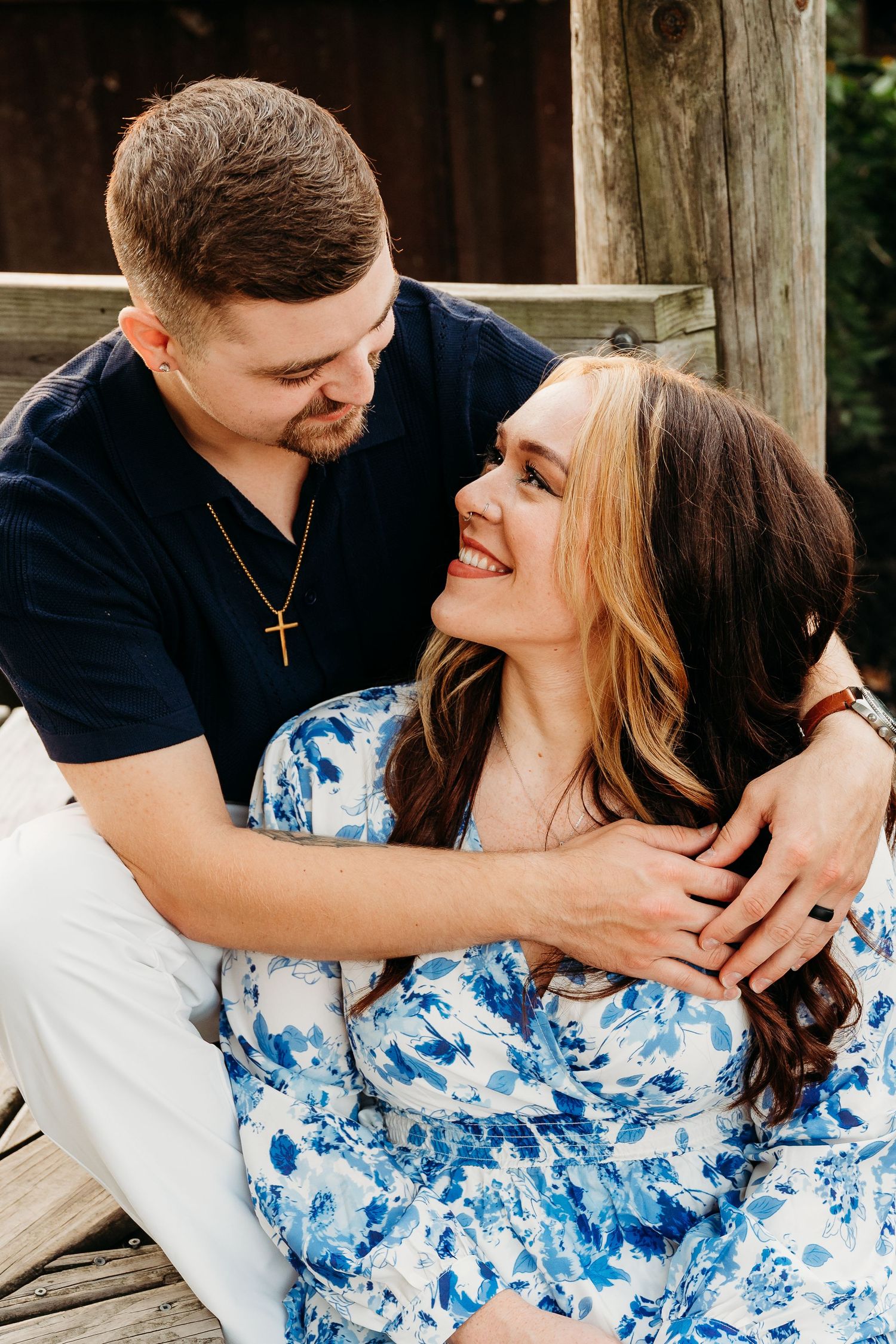Couple sharing intimate moments in a series of romantic outdoor photos wearing blue floral dress and navy shirt.