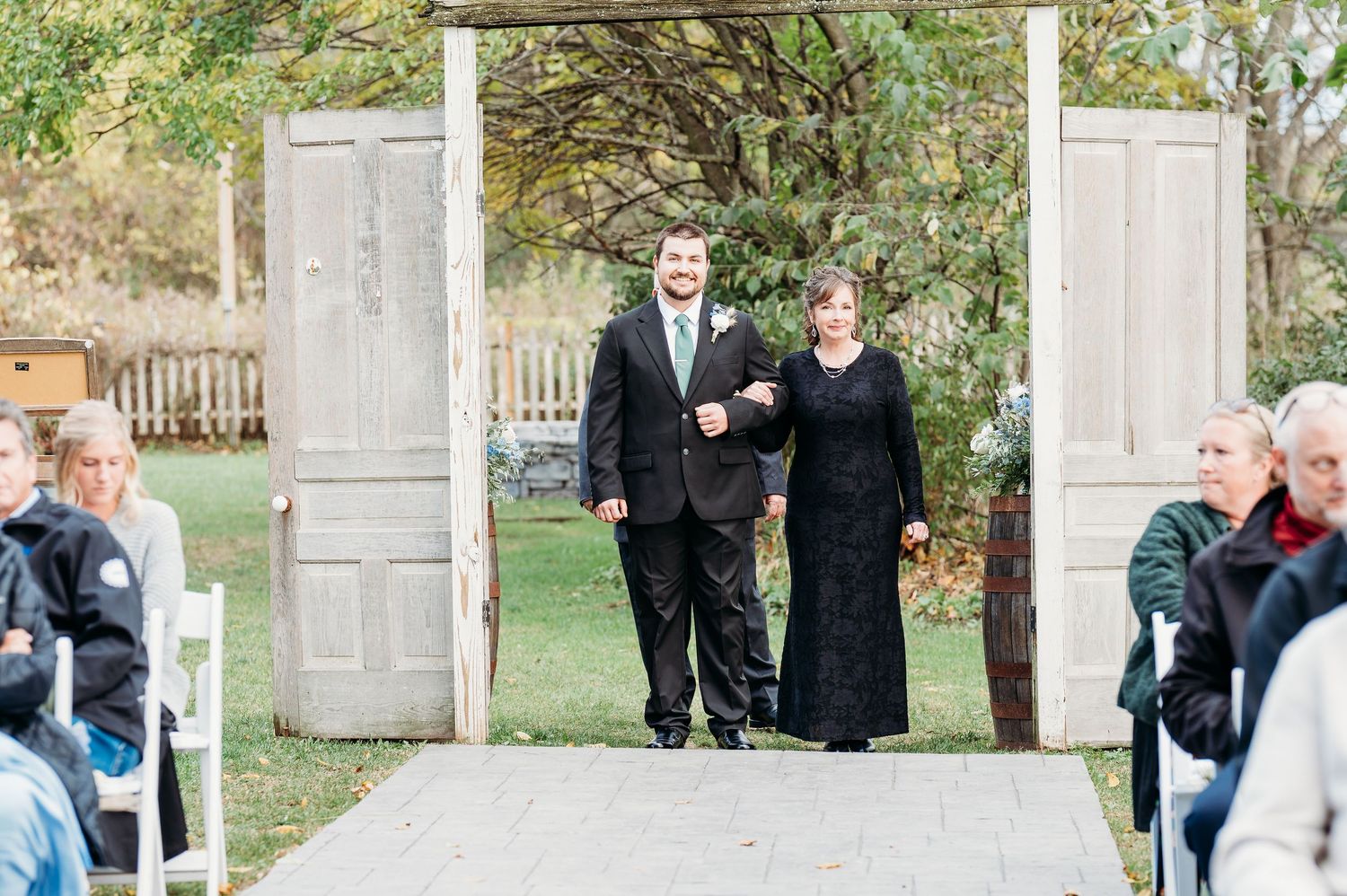 A series of outdoor wedding photos with people posing in front of white vintage doors arranged in a garden setting.