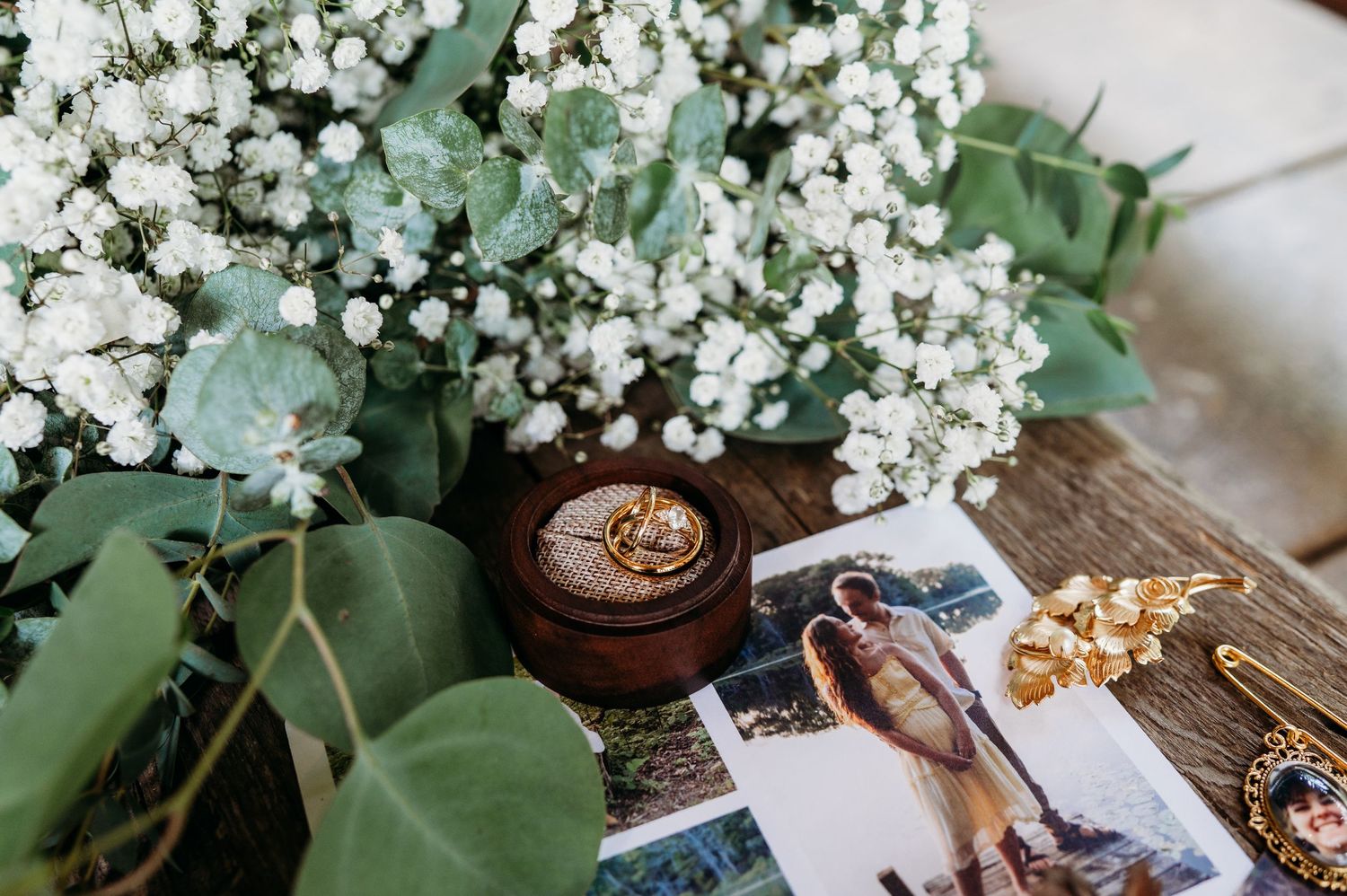 White baby's breath flowers and green eucalyptus leaves create a romantic floral arrangement with vintage accessories.