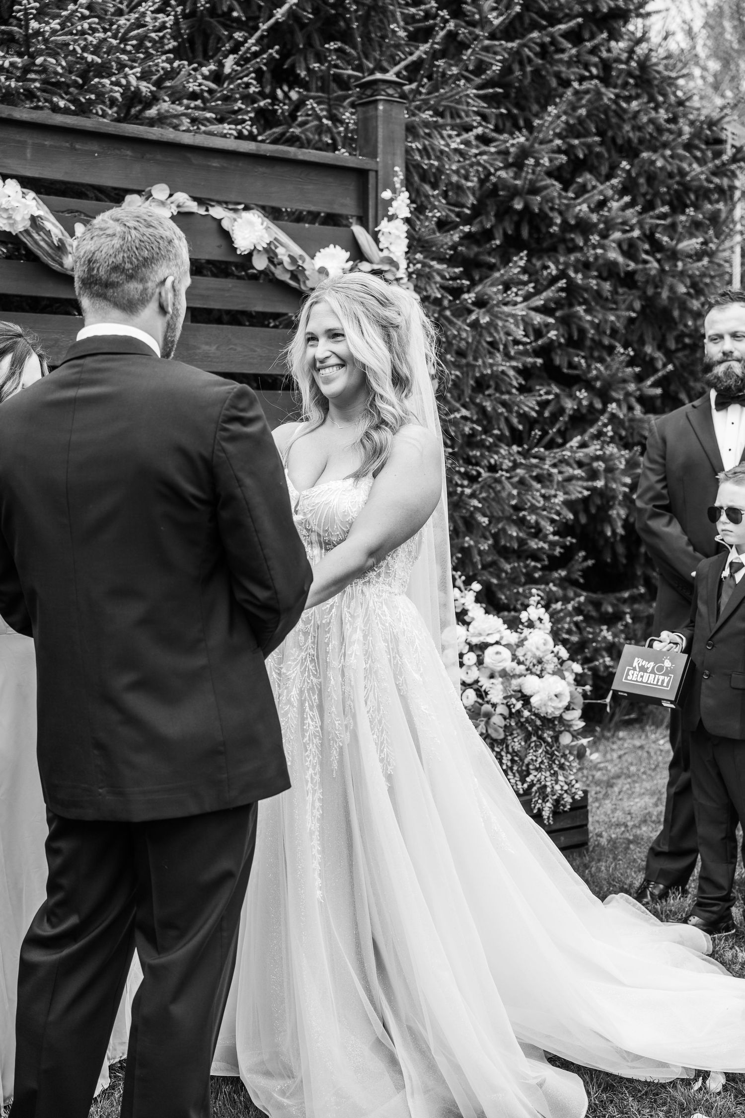 A series of black and white wedding photos showing tender moments between a bride and groom during an outdoor ceremony.
