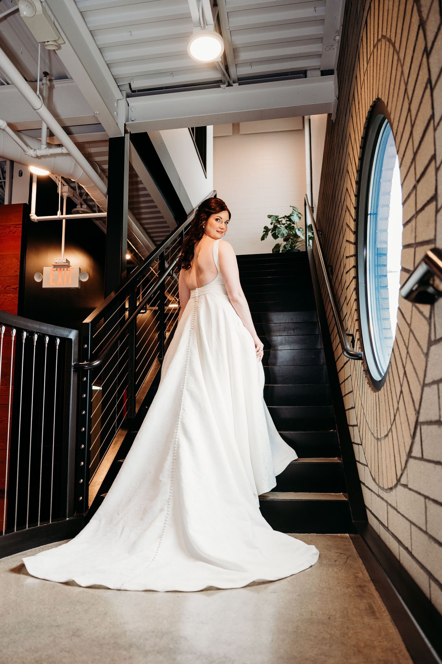 Series of wedding dress portraits showing the dramatic silhouette and long train against an industrial interior backdrop.